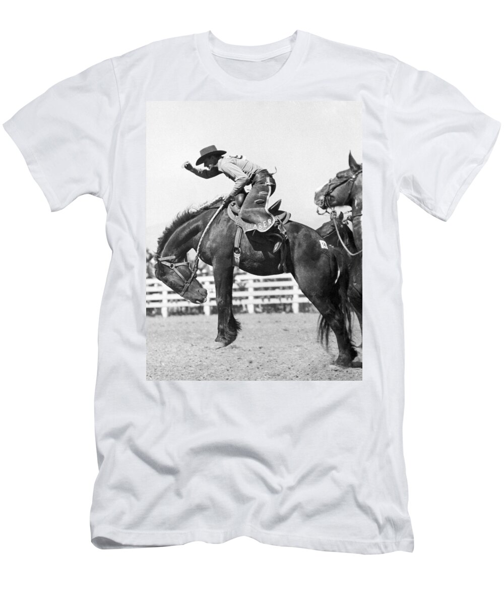 1035-1001 T-Shirt featuring the photograph Riding A Bucking Bronco #2 by Underwood Archives