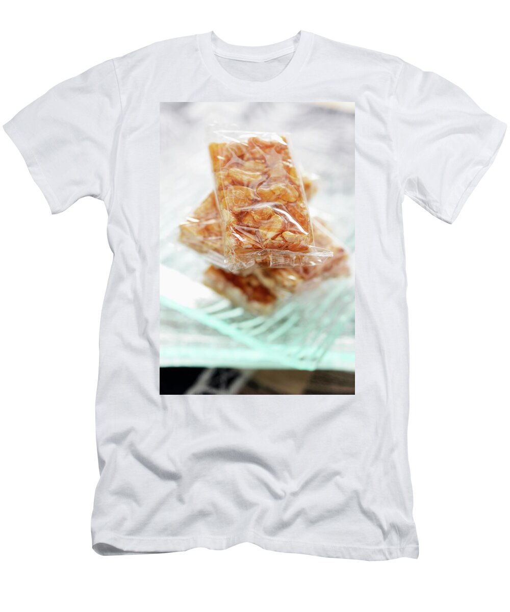 Ip_11194148 T-Shirt featuring the photograph Peanut Brittle, Wrapped In Cellophane Paper by Caste, Alain
