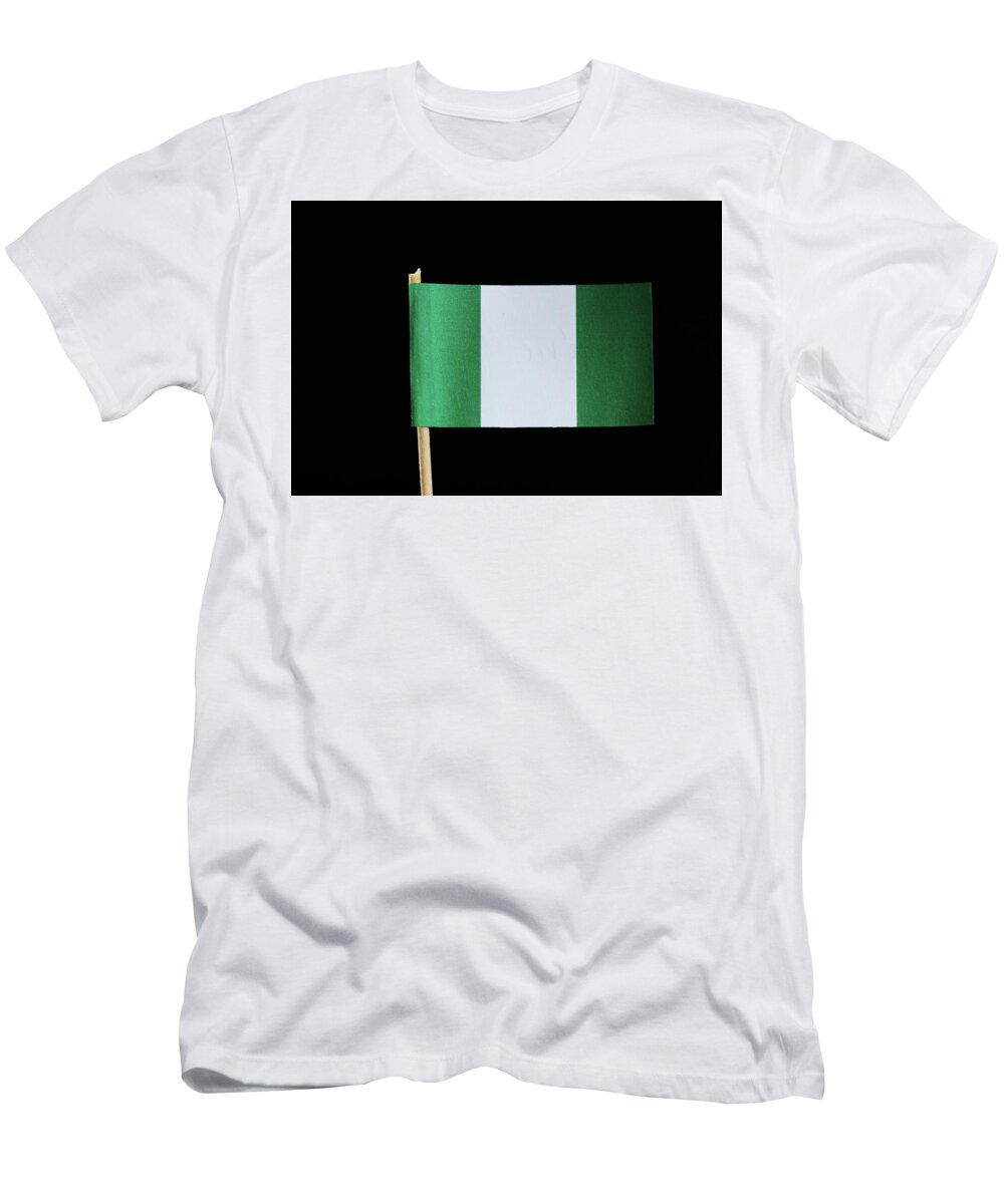 Federal Republic Of Nigeria T-Shirt featuring the photograph A national flag of Nigeria on toothpick on black background. Nigerian flag contain green and white colour. by Vaclav Sonnek