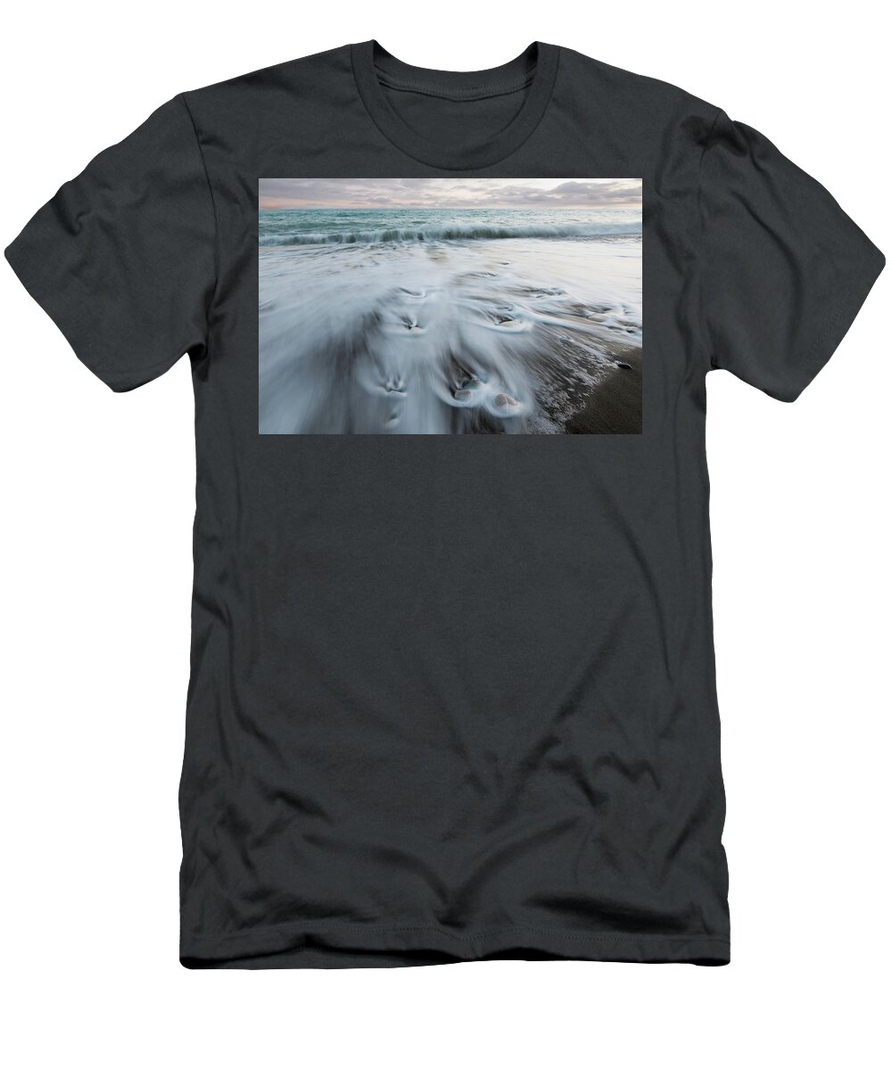 Coastline T-Shirt featuring the photograph Pebbles in the beach and flowing sea water by Michalakis Ppalis
