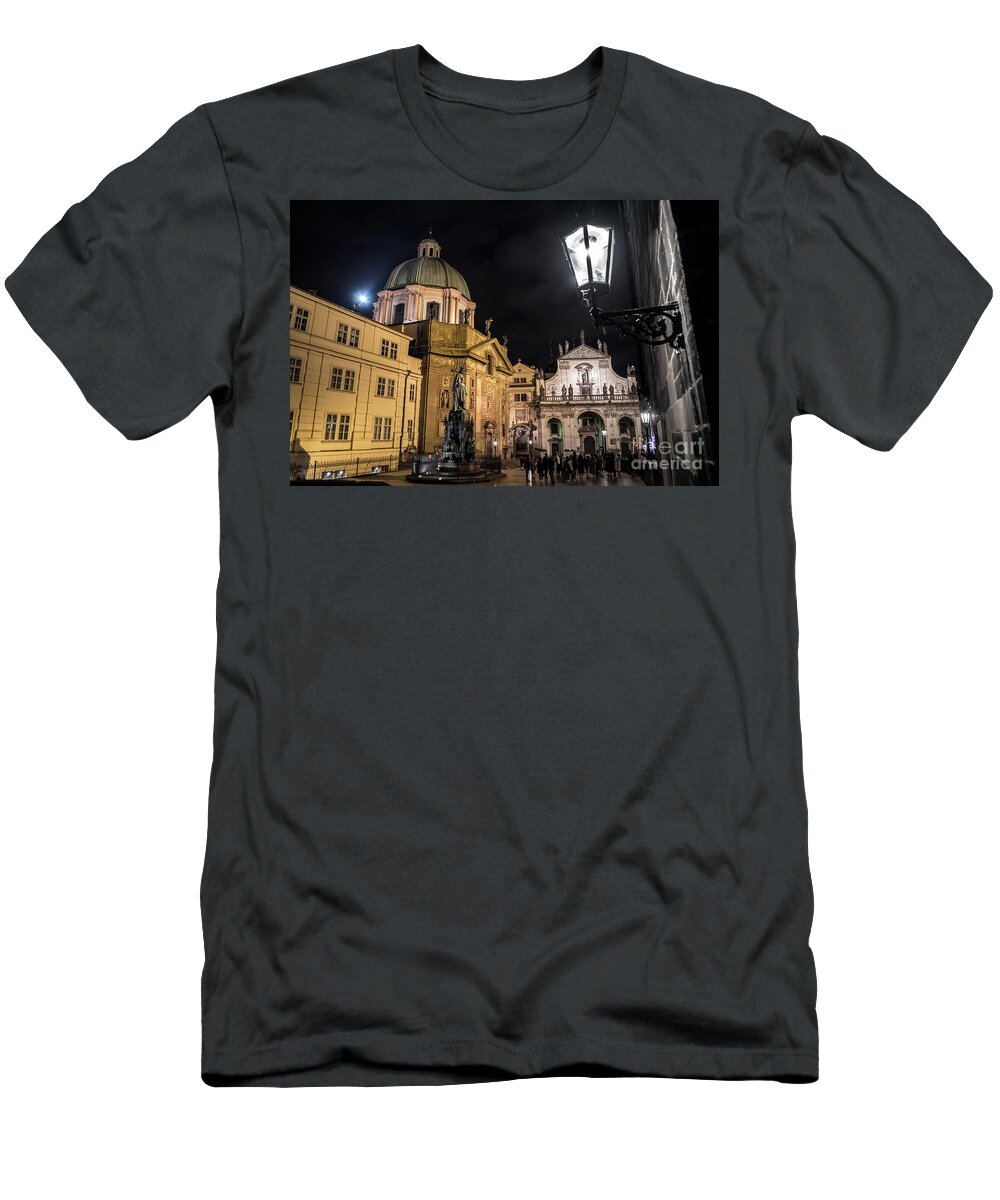 Prague T-Shirt featuring the photograph Historic Buildings Beneath The Tower Of Charles Bridge In The Night In Prague In The Czech Republic #1 by Andreas Berthold