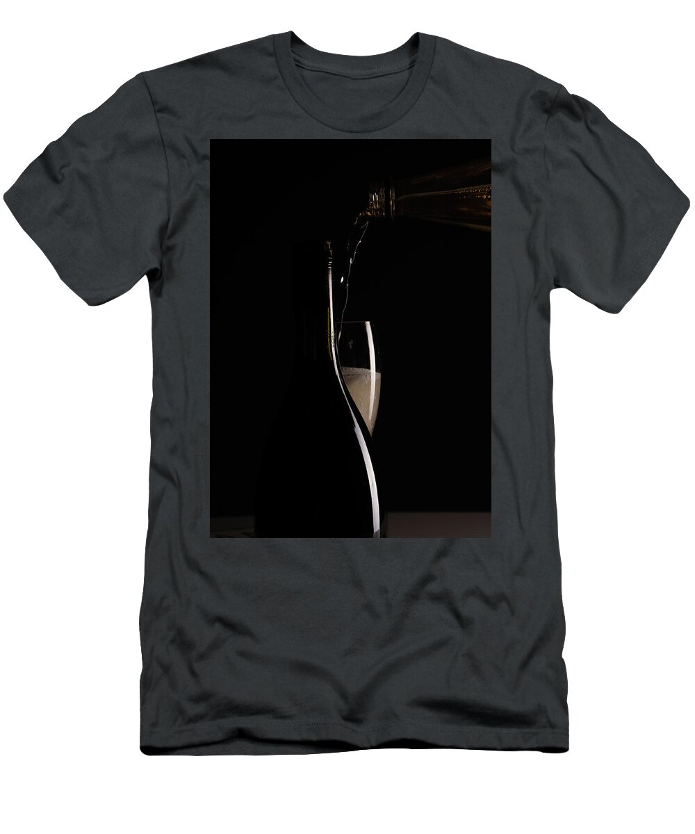 Red Wine T-Shirt featuring the photograph Red sparking wine on a wineglass and black wine bottle. #1 by Michalakis Ppalis