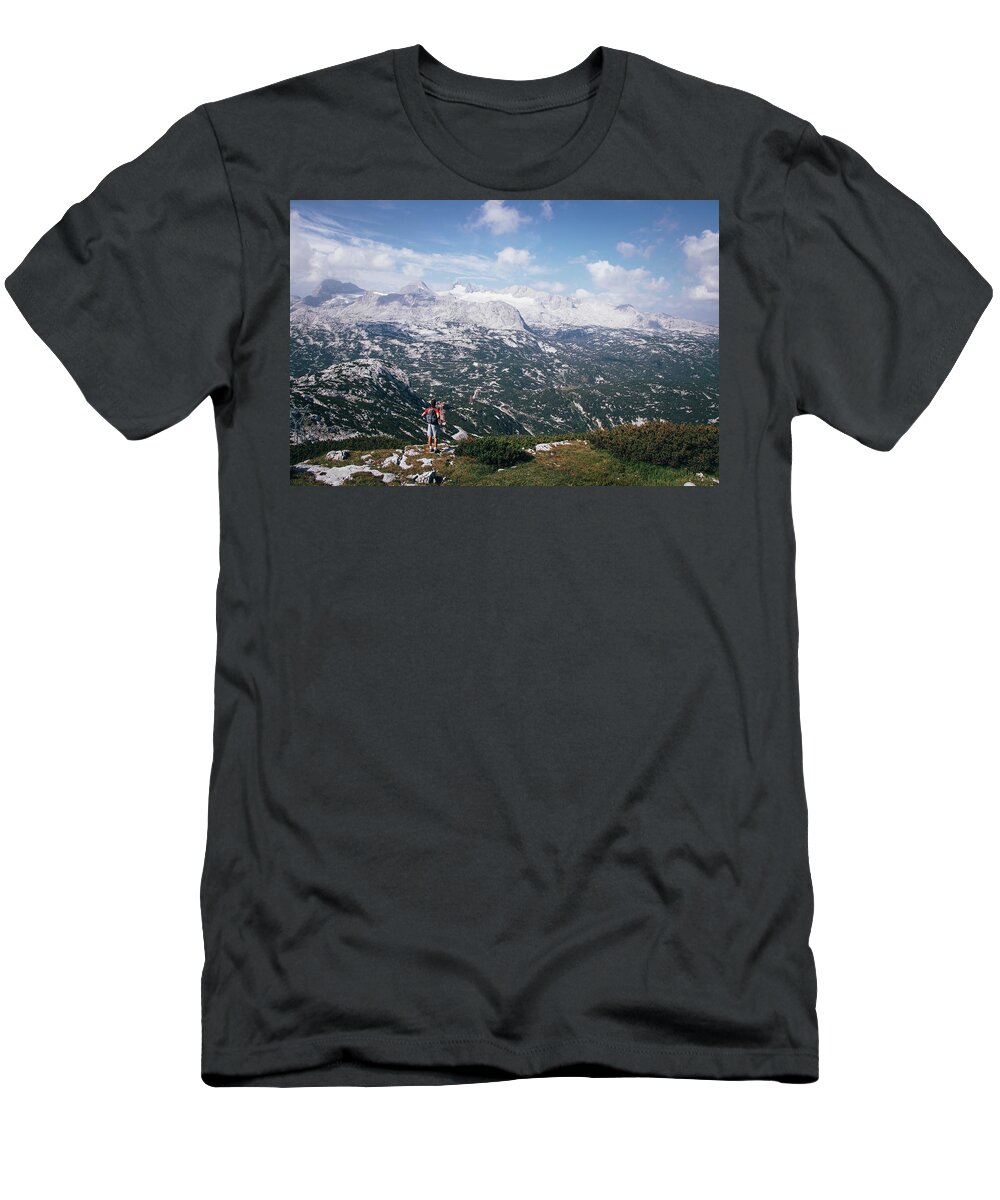 Sportive T-Shirt featuring the photograph Man with a backpack looks at the Dachstein massif by Vaclav Sonnek