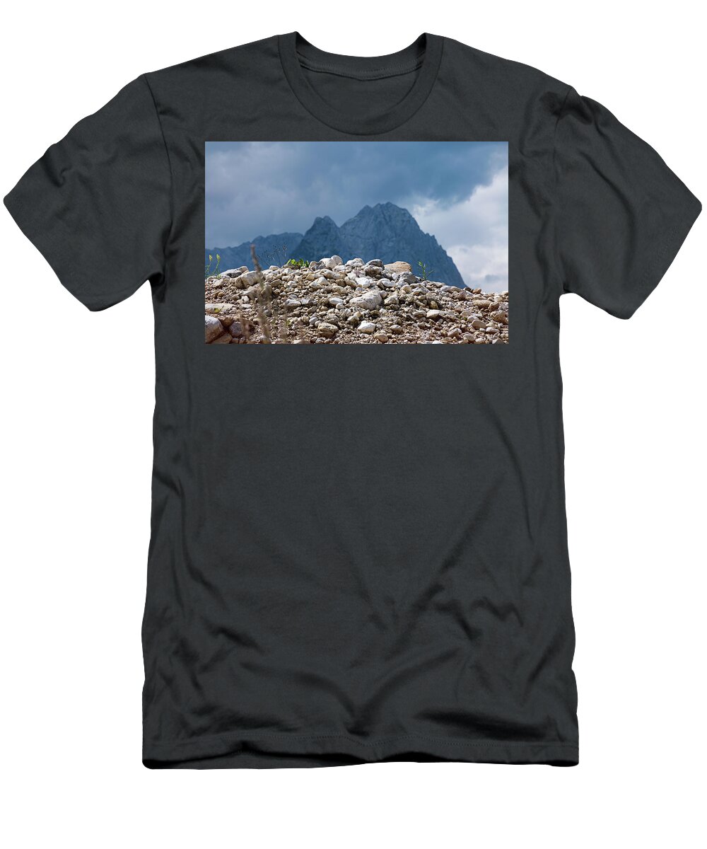 Mountains T-Shirt featuring the photograph Stony hill with plants in front of a mountain range. by Bernhard Schaffer