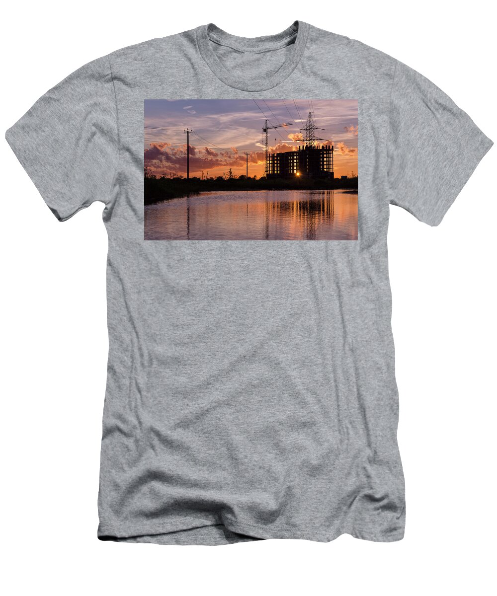 Sky T-Shirt featuring the photograph Industrial construction cranes and building silhouettes over sun by Maya Afzaal