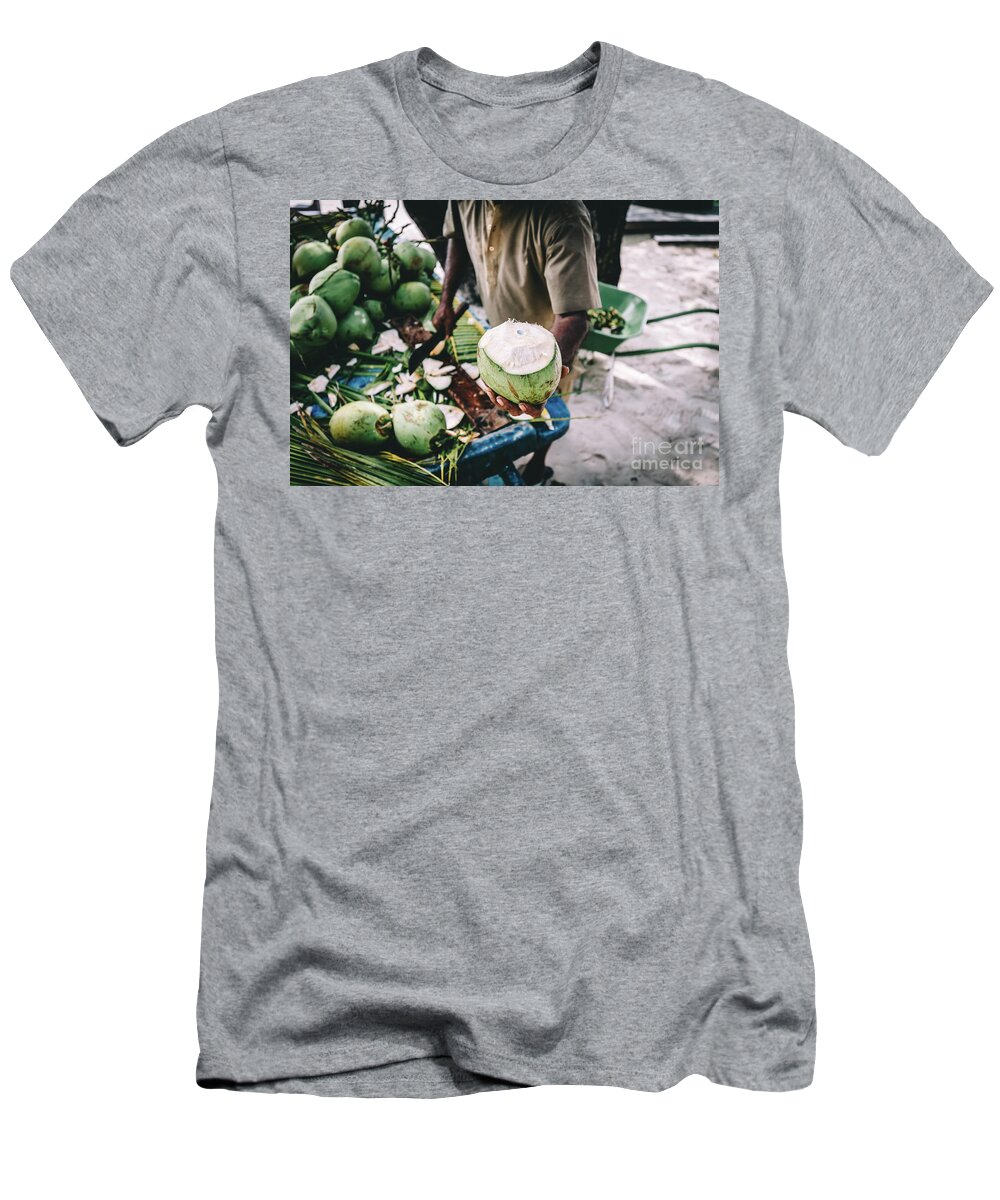 Man T-Shirt featuring the photograph Man handing in a green coconut. Traditional local agriculture. by Michal Bednarek