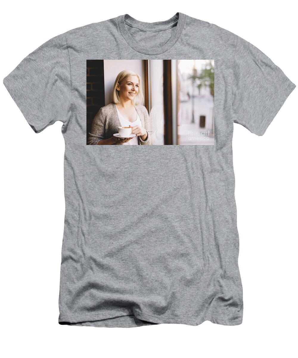 Woman T-Shirt featuring the photograph Woman with a cup of coffee standing by the window. by Michal Bednarek
