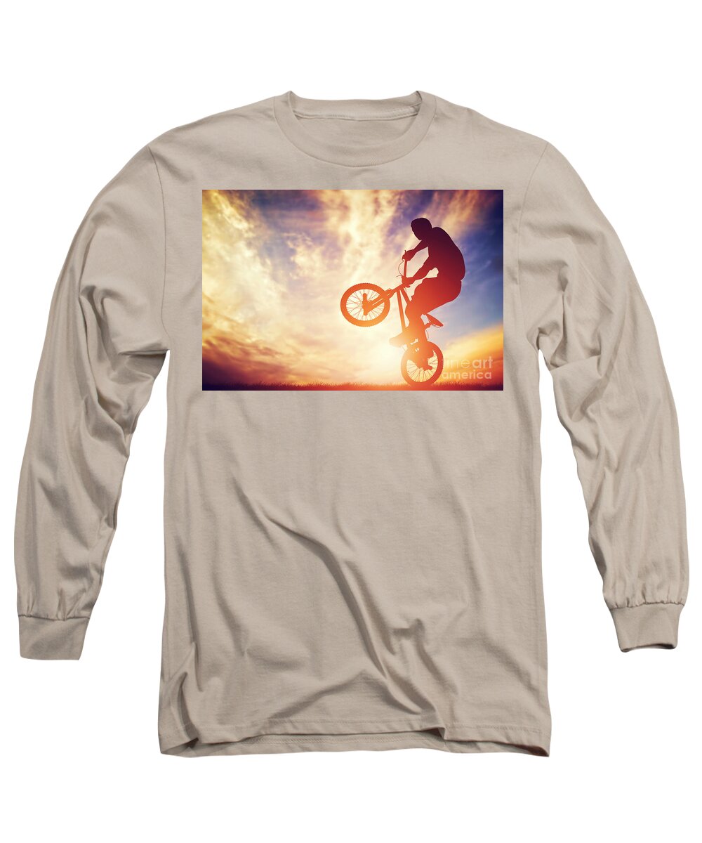 Bike Long Sleeve T-Shirt featuring the photograph Man riding a bmx bike performing a trick against sunset sky by Michal Bednarek