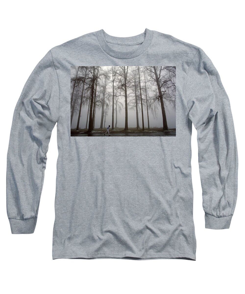 Exercise Long Sleeve T-Shirt featuring the photograph Runner along path in fog and cold with tall trees by Jim Corwin
