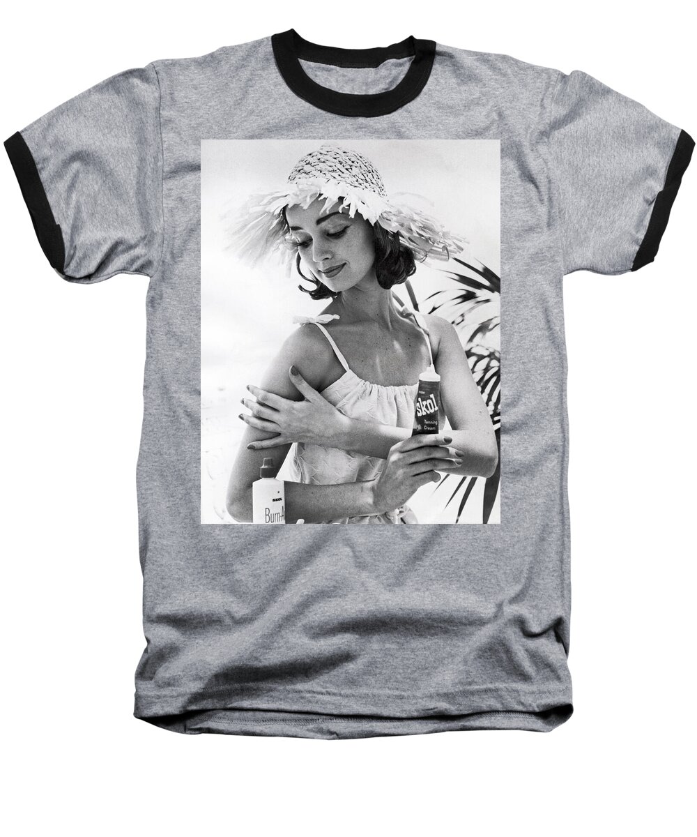  Baseball T-Shirt featuring the photograph Young Woman Applies Tanning Cream by Underwood Archives