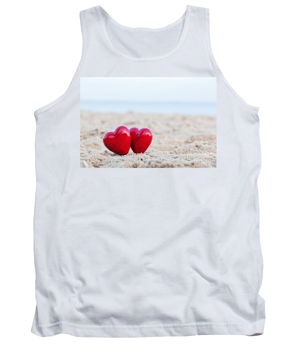 Heart Tank Top featuring the photograph Two red hearts on the beach symbolizing love by Michal Bednarek