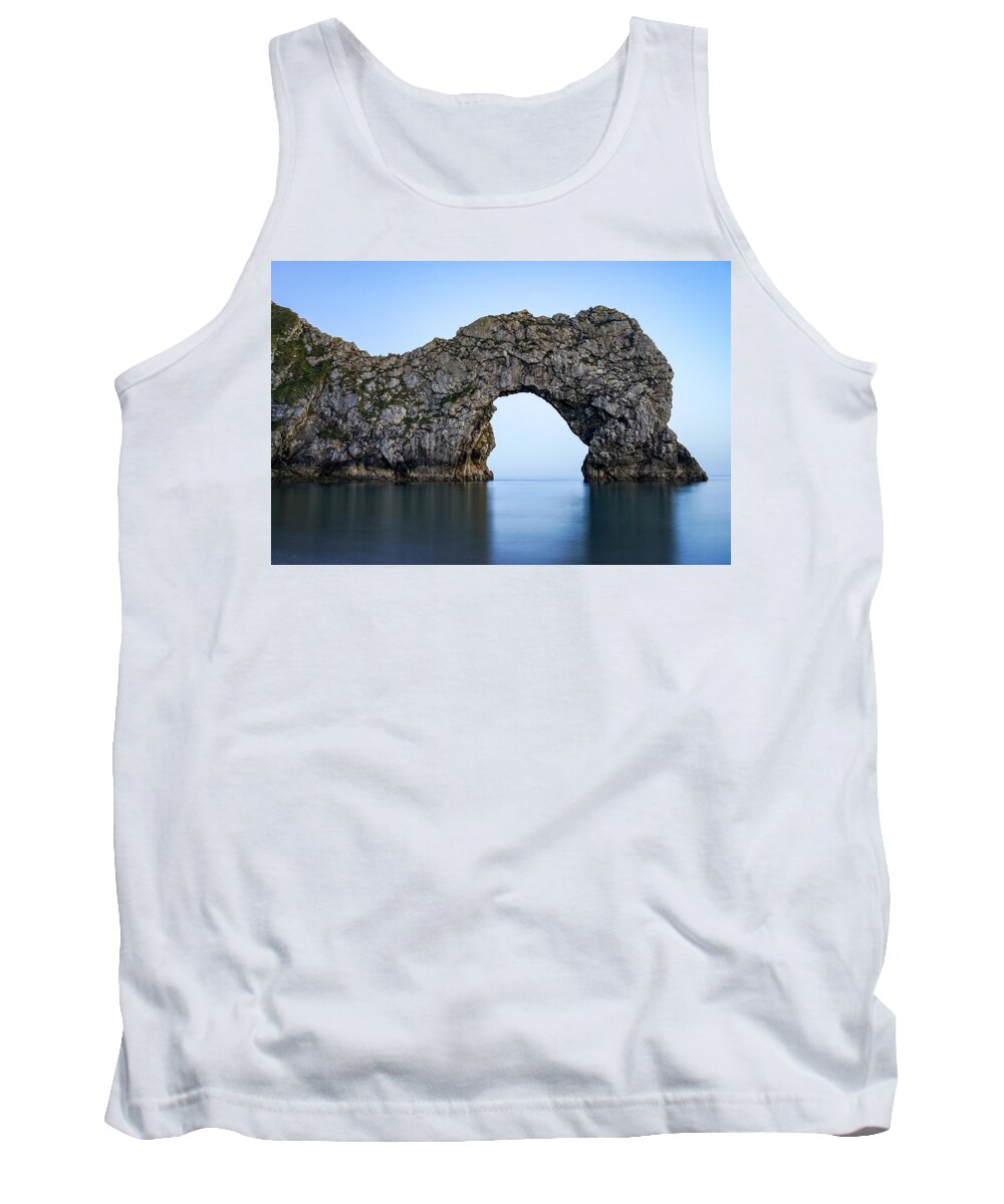 Durdle Door Tank Top featuring the photograph Durdle door in England seen at blue hour. by George Afostovremea
