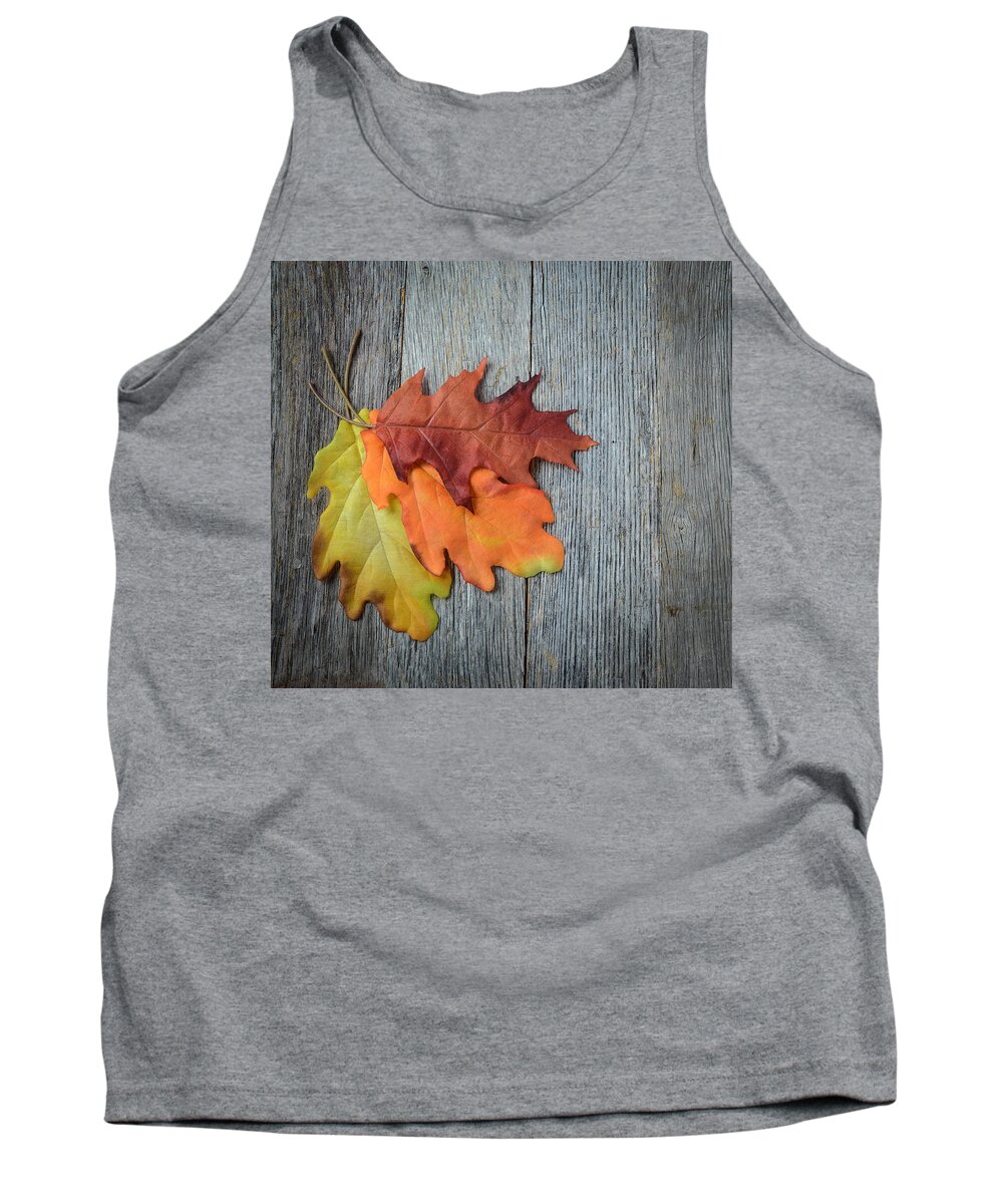 Macro Tank Top featuring the photograph Autumn Leaves On Rustic Wooden Background #1 by Brandon Bourdages