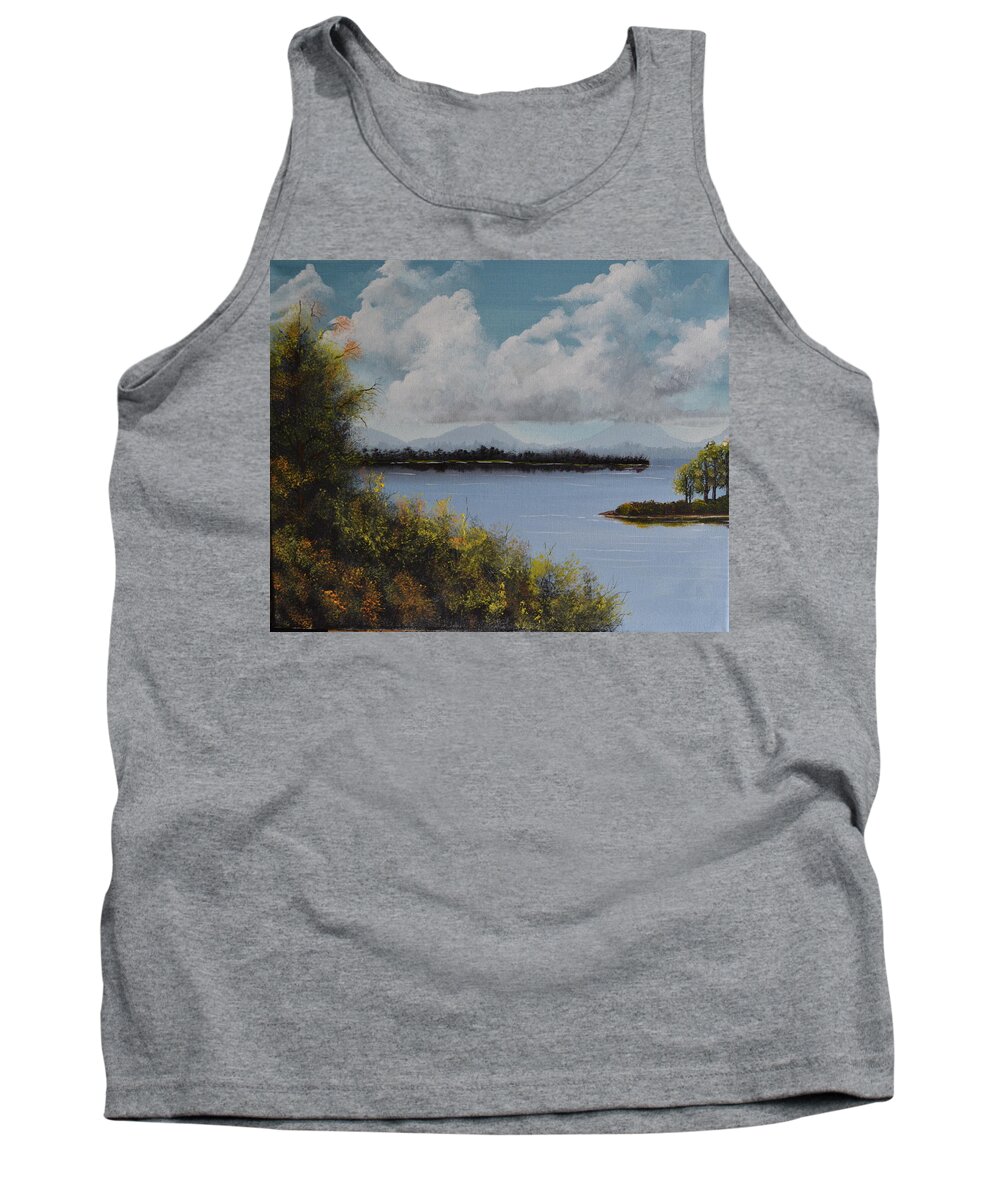 A Landscape Of A Large Blue Lake With A Bright Sky Containing Clouds. There Are Distant Mountains And Two Inlets On The Lake. In The Fore Ground Are Multi-colored Brushes With A Tree Containing Different Colored Leaves. Tank Top featuring the painting Fall Lake by Martin Schmidt