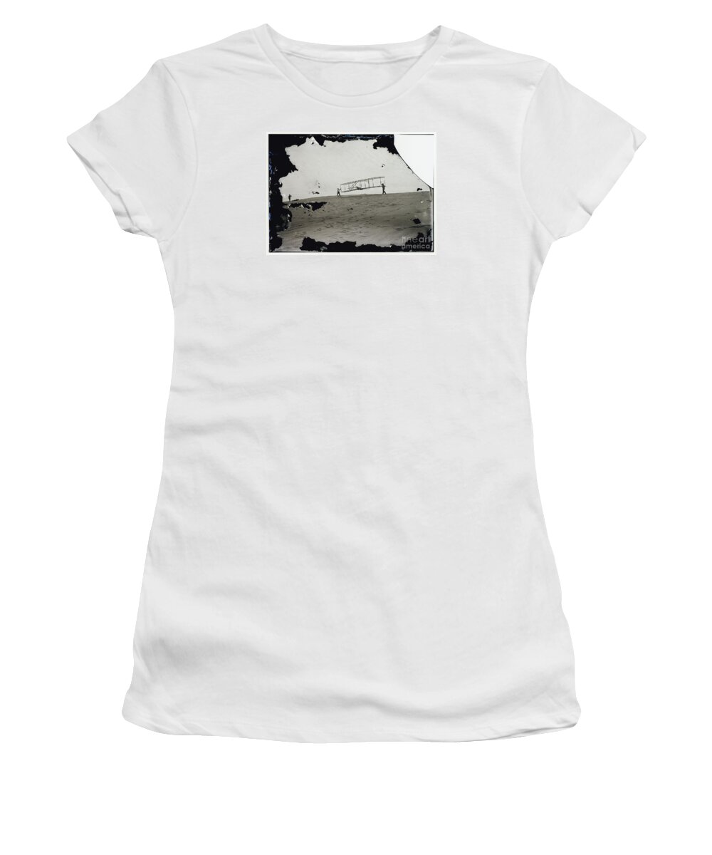 The Wright Brothers Women's T-Shirt featuring the photograph The Wright Brothers Wilbur in motion at left holding one end of glider by Vintage Collectables