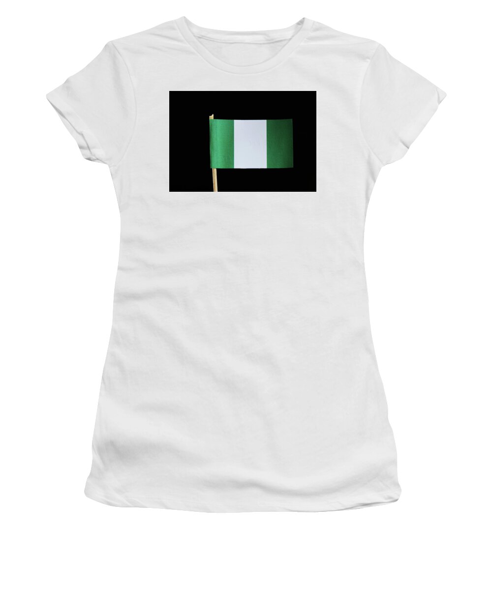 Federal Republic Of Nigeria Women's T-Shirt featuring the photograph A national flag of Nigeria on toothpick on black background. Nigerian flag contain green and white colour. by Vaclav Sonnek