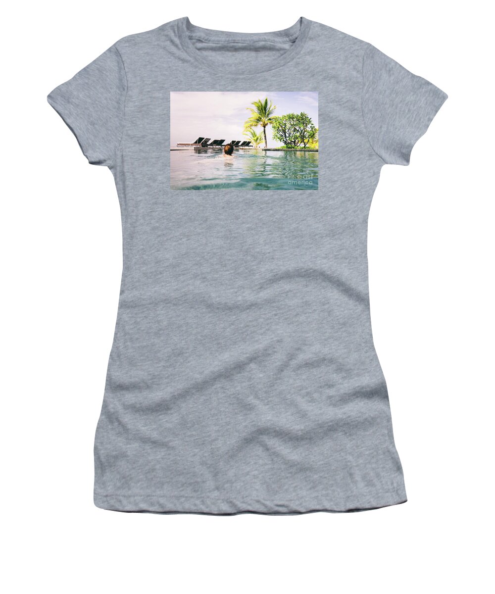 Summer Women's T-Shirt featuring the photograph Woman swimming in a hotel pool in a tropical resort. by Michal Bednarek