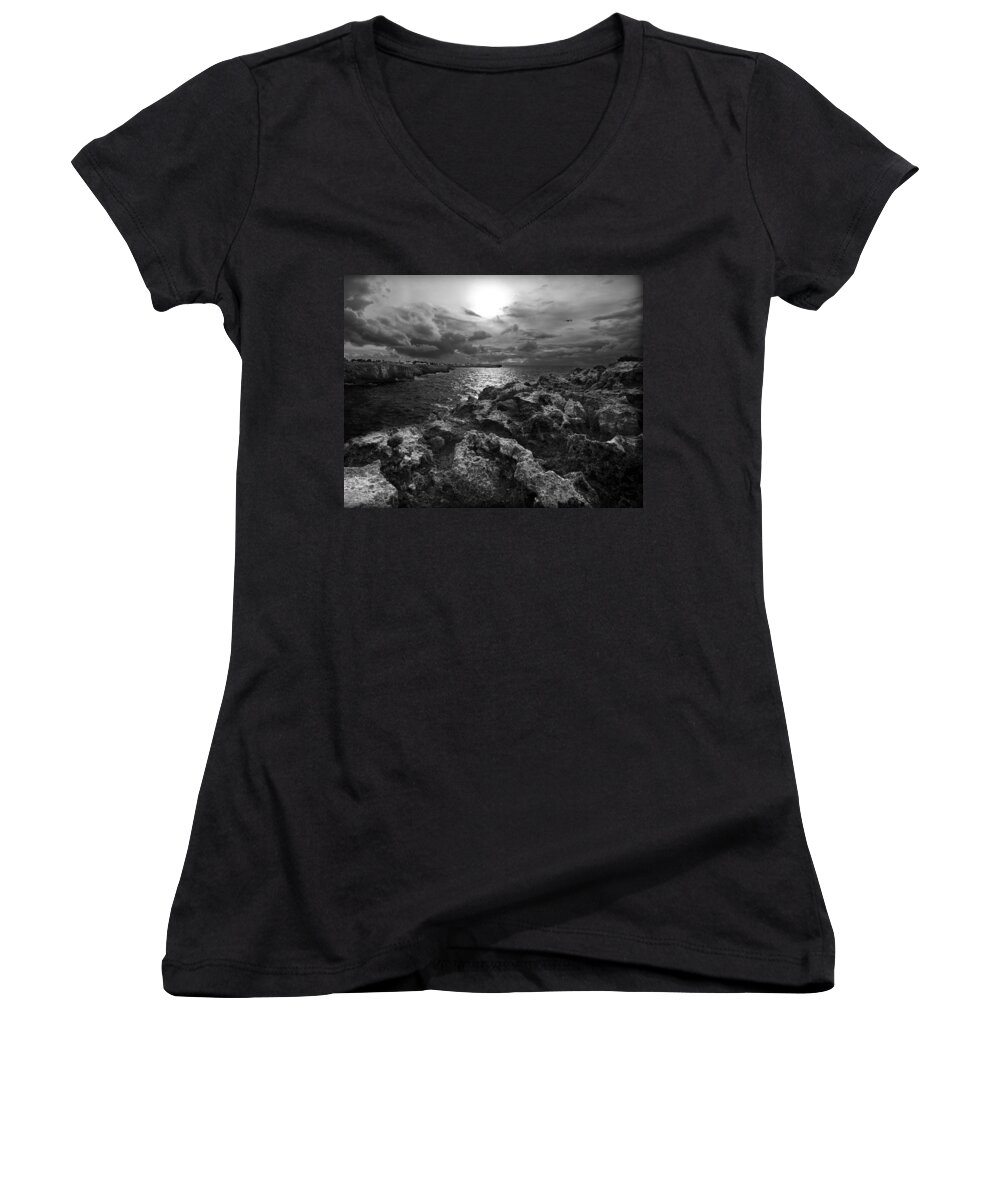 Background Women's V-Neck featuring the photograph Blank and white stormy mediterranean sunrise in contrast with black rocks and cliffs in Menorca by Pedro Cardona Llambias