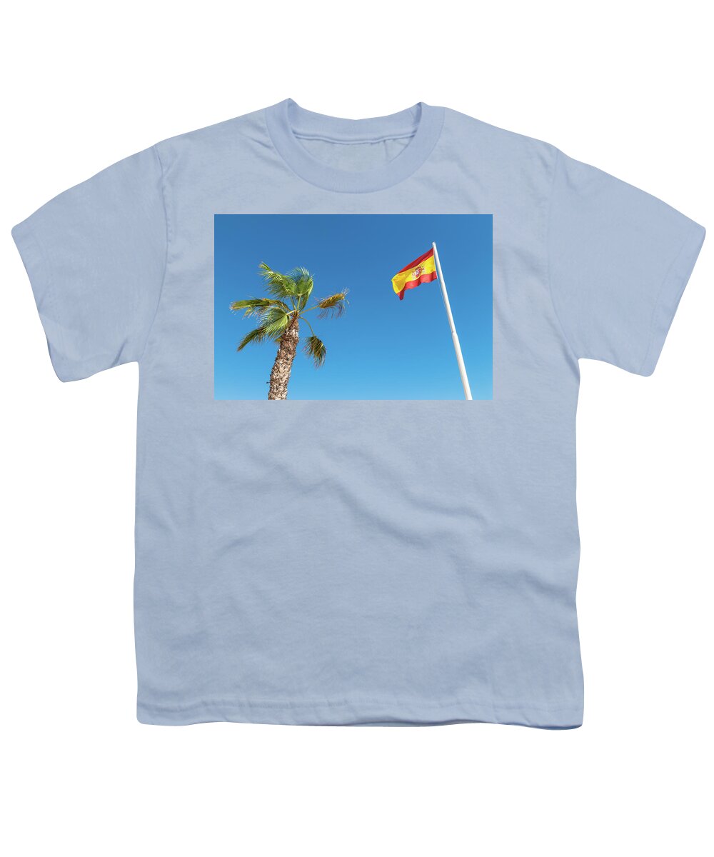 Spain Youth T-Shirt featuring the photograph Spanish flag and palm tree in the blue sky by GoodMood Art