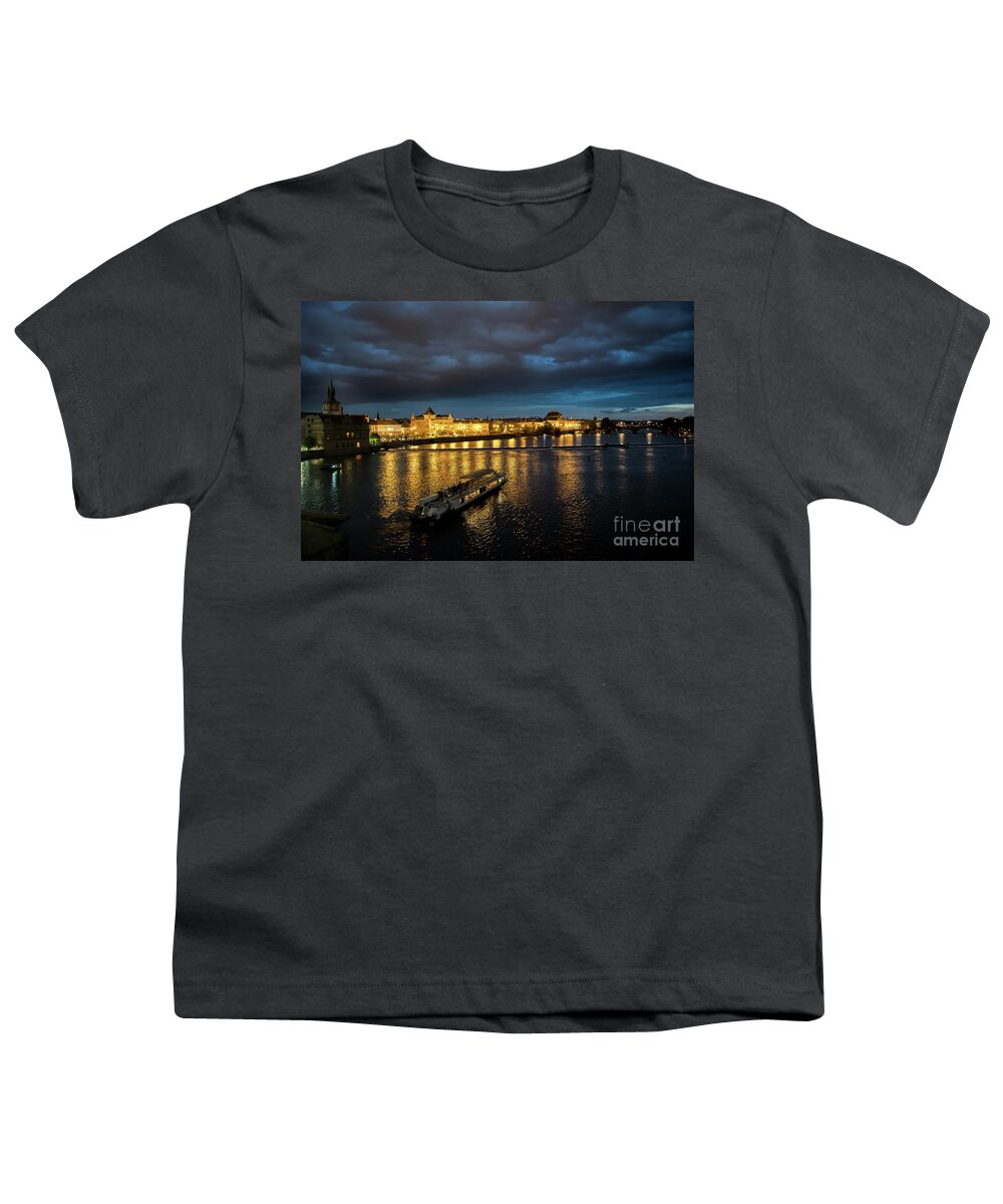 Architecture Youth T-Shirt featuring the photograph Illuminated Moldova River With Ship And Buildings In The Night In Prague In The Czech Republic by Andreas Berthold