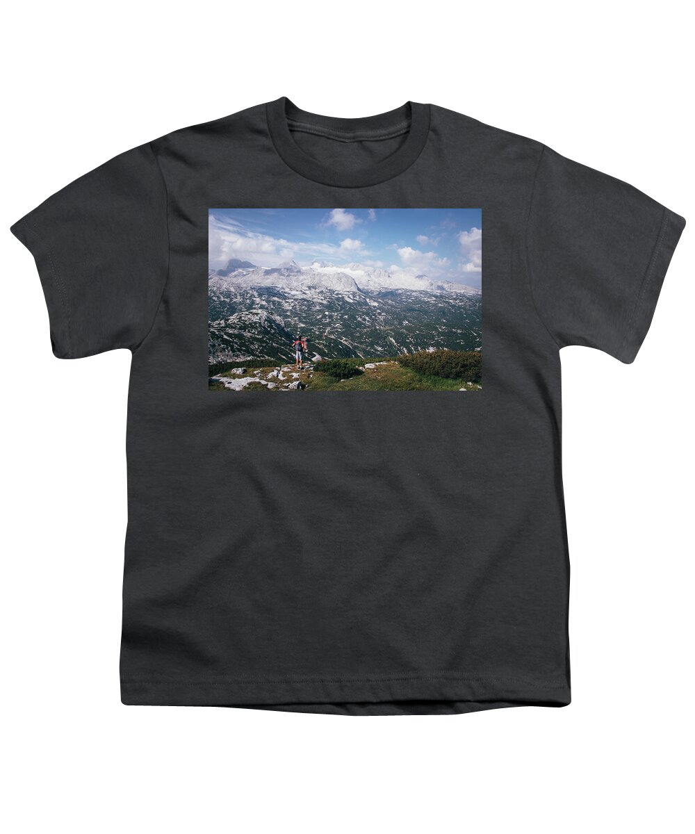 Sportive Youth T-Shirt featuring the photograph Man with a backpack looks at the Dachstein massif by Vaclav Sonnek