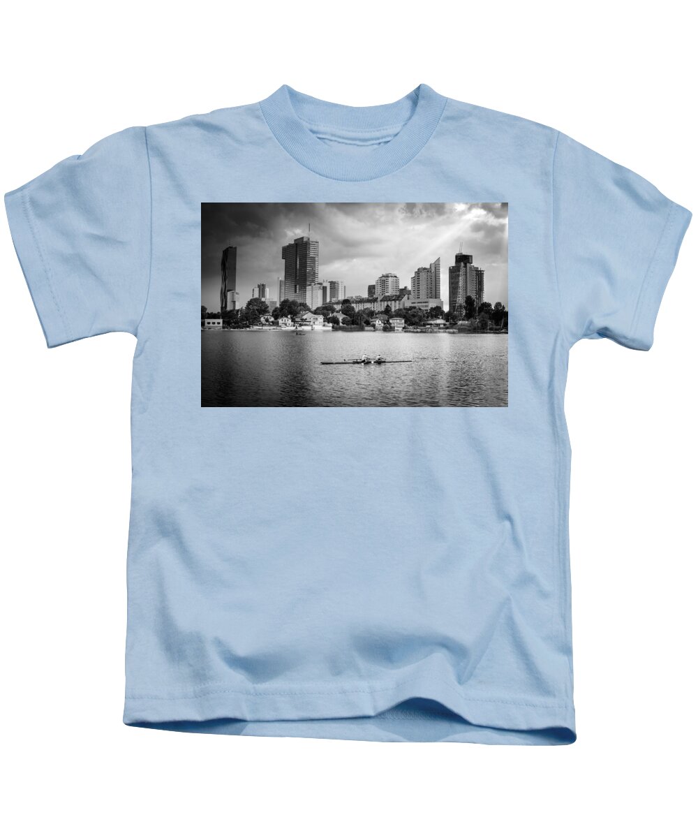 Skyline Kids T-Shirt featuring the photograph Rowing Boat And The Skyline Of Vienna #2 by Andreas Berthold