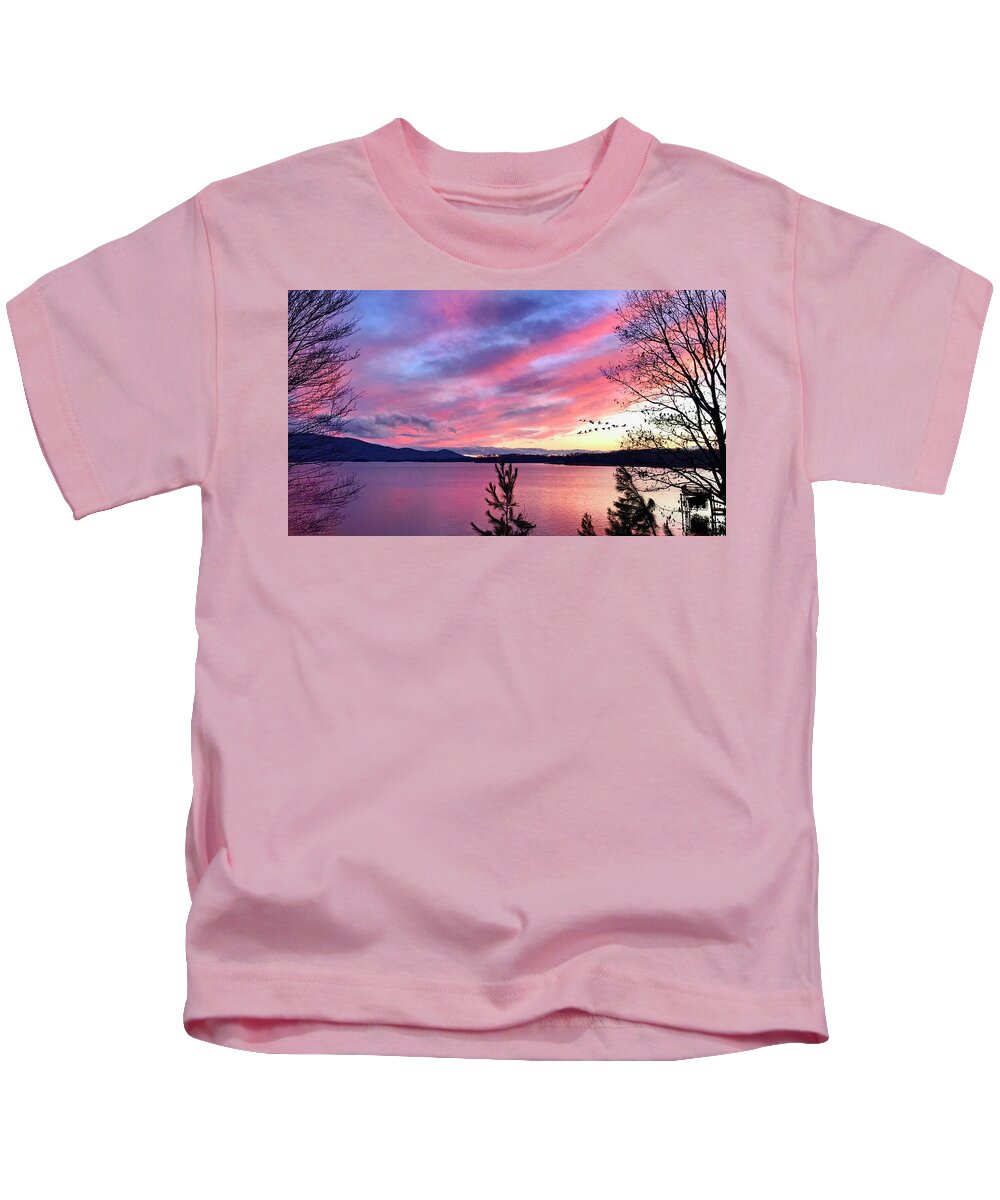 Canadian Geese Kids T-Shirt featuring the photograph Canadian Geese over Smith Mountain Lake at Sunset. by The James Roney Collection