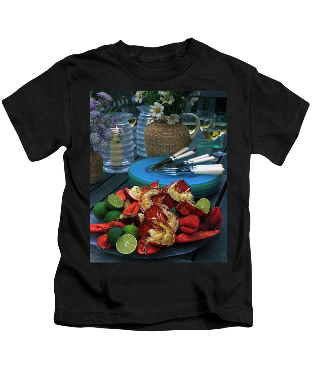 Still Life Kids T-Shirt featuring the photograph A Meal With Lobster And Limes by Romulo Yanes