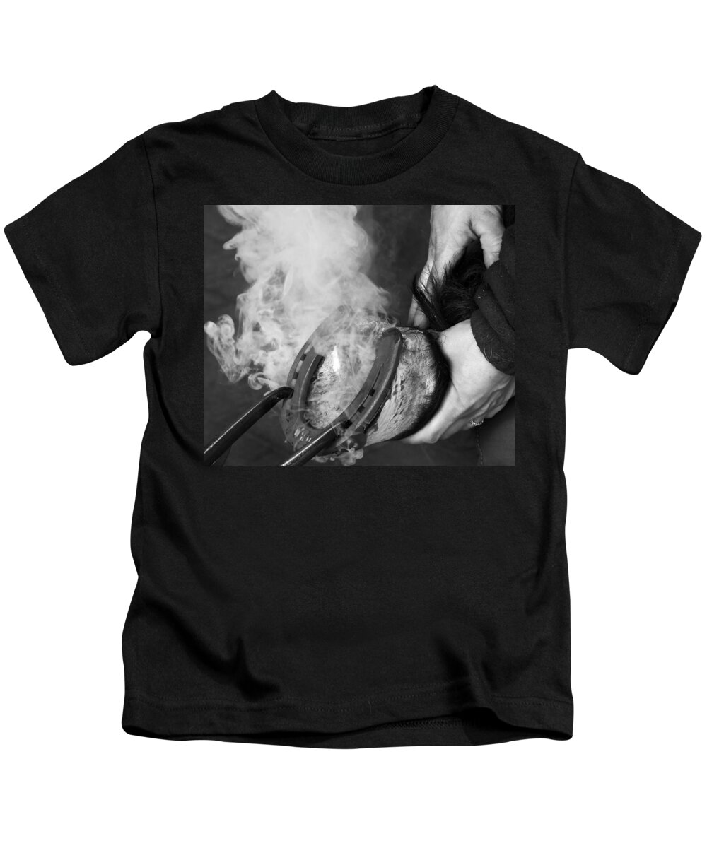 Blacksmith Kids T-Shirt featuring the photograph Blacksmith with horseshoe - traditional craft by Matthias Hauser