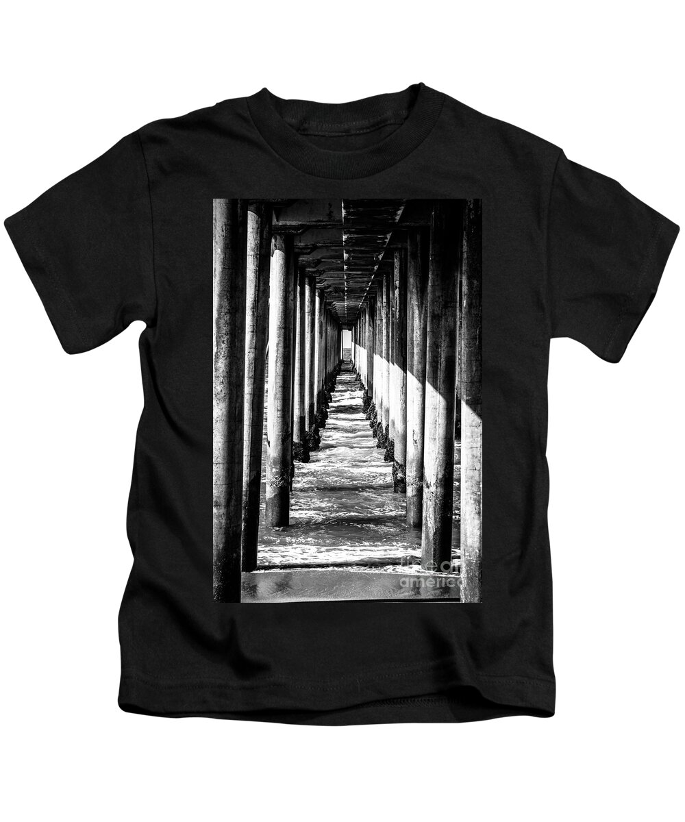 America Kids T-Shirt featuring the photograph Under Huntington Beach Pier Black and White Picture by Paul Velgos
