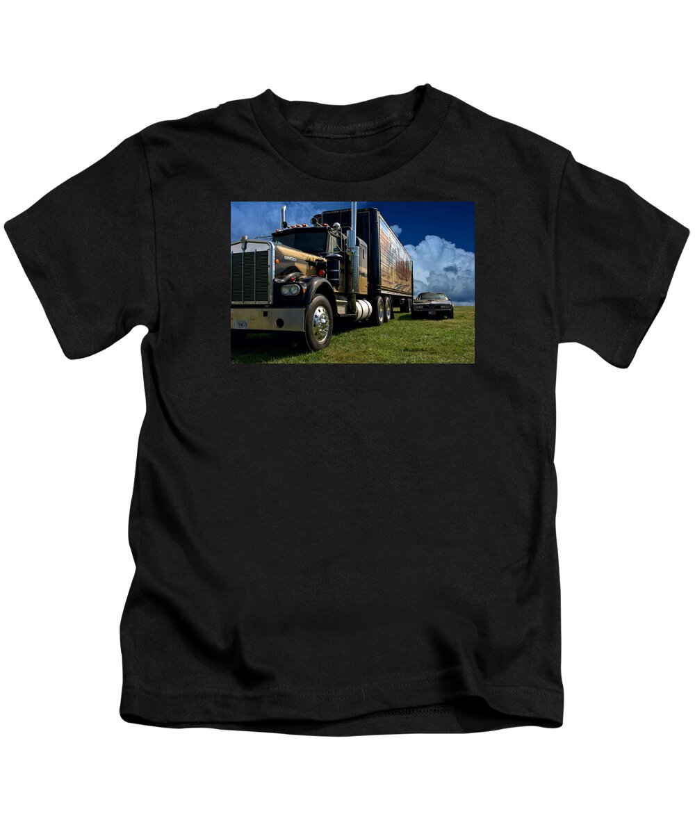 1973 Kids T-Shirt featuring the photograph Smokey and the Bandit Tribute 1973 Kenworth W900 Black and Gold Semi Truck and The Bandit TransAm by Tim McCullough