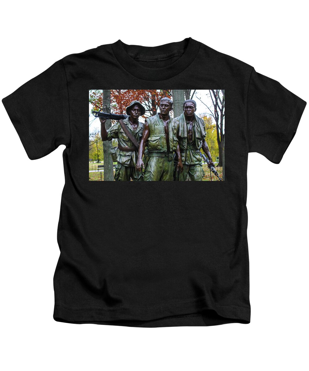 This Is A Photo Of The Three Soldiers In Washington D.c. Dedicated To The Soldiers Of The Vietnam War. This Well-known Sculpture By Frederick Hart Portrays Three Young Uniformed American Soldiers. While The Military Attire Is Meant To Be Symbolic And General In Nature Kids T-Shirt featuring the photograph The Three Soldiers #1 by Bill Rogers