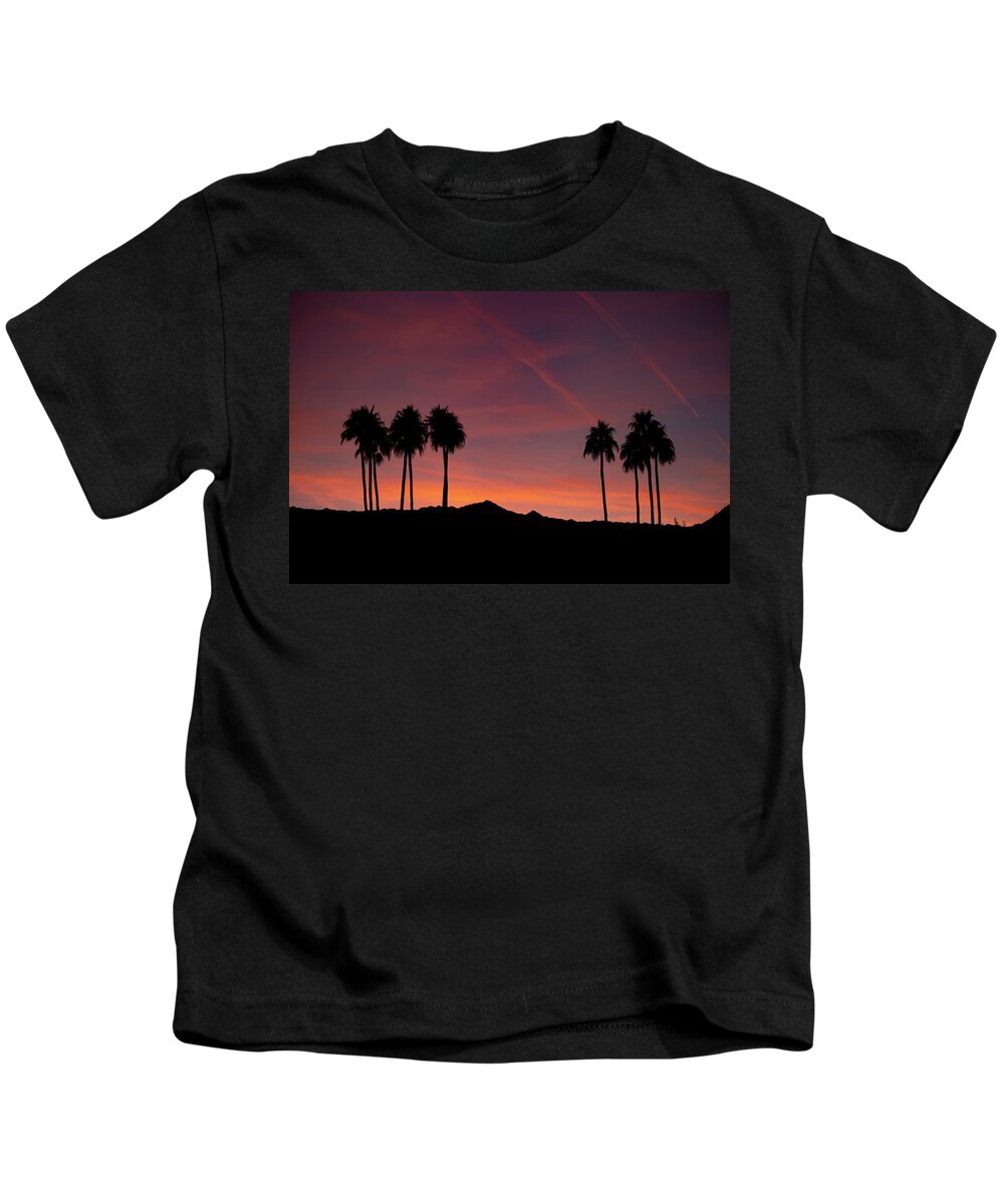 Afterglow Kids T-Shirt featuring the photograph 10 Palm Silhouettes at Sunset Palm Desert California by Bonnie Colgan