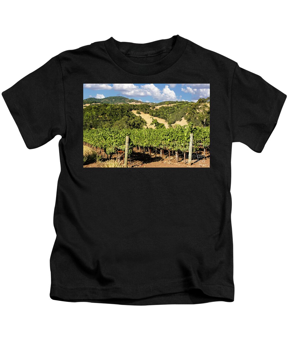 Clouds Kids T-Shirt featuring the photograph White puffy clouds over the Napa Valley hills full of wine grapes and lines and lines of vineyards. by Gunther Allen