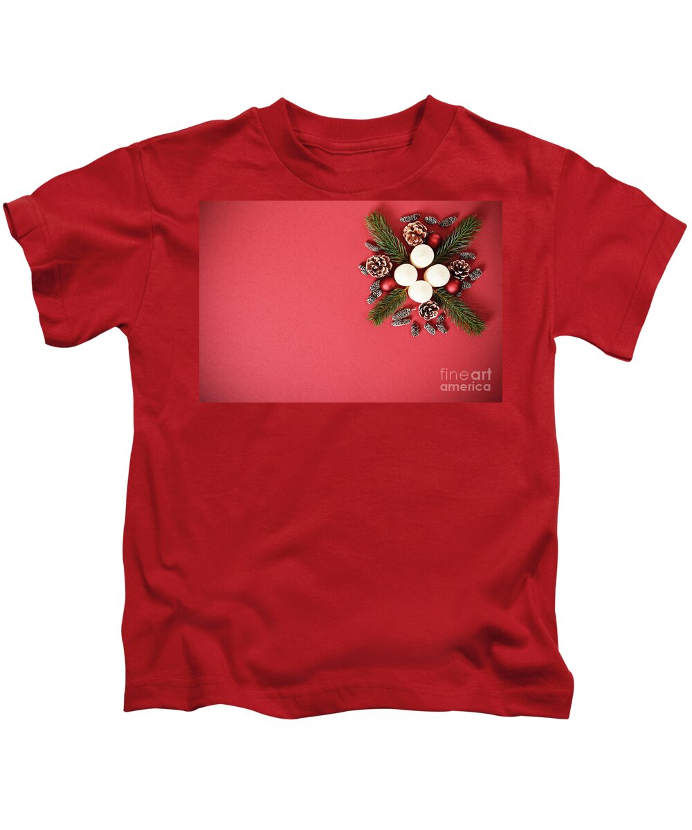 Seasonal Kids T-Shirt featuring the photograph Seasonal greeting card concept with candles, pine cones and everg by Mendelex Photography