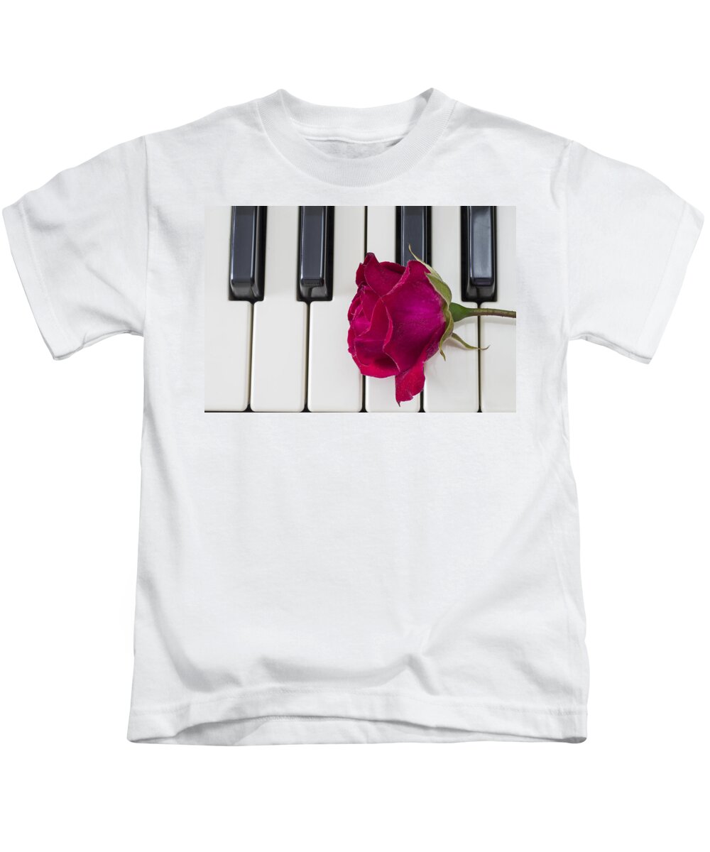 Piano Kids T-Shirt featuring the photograph Rose over piano keys by Paulo Goncalves
