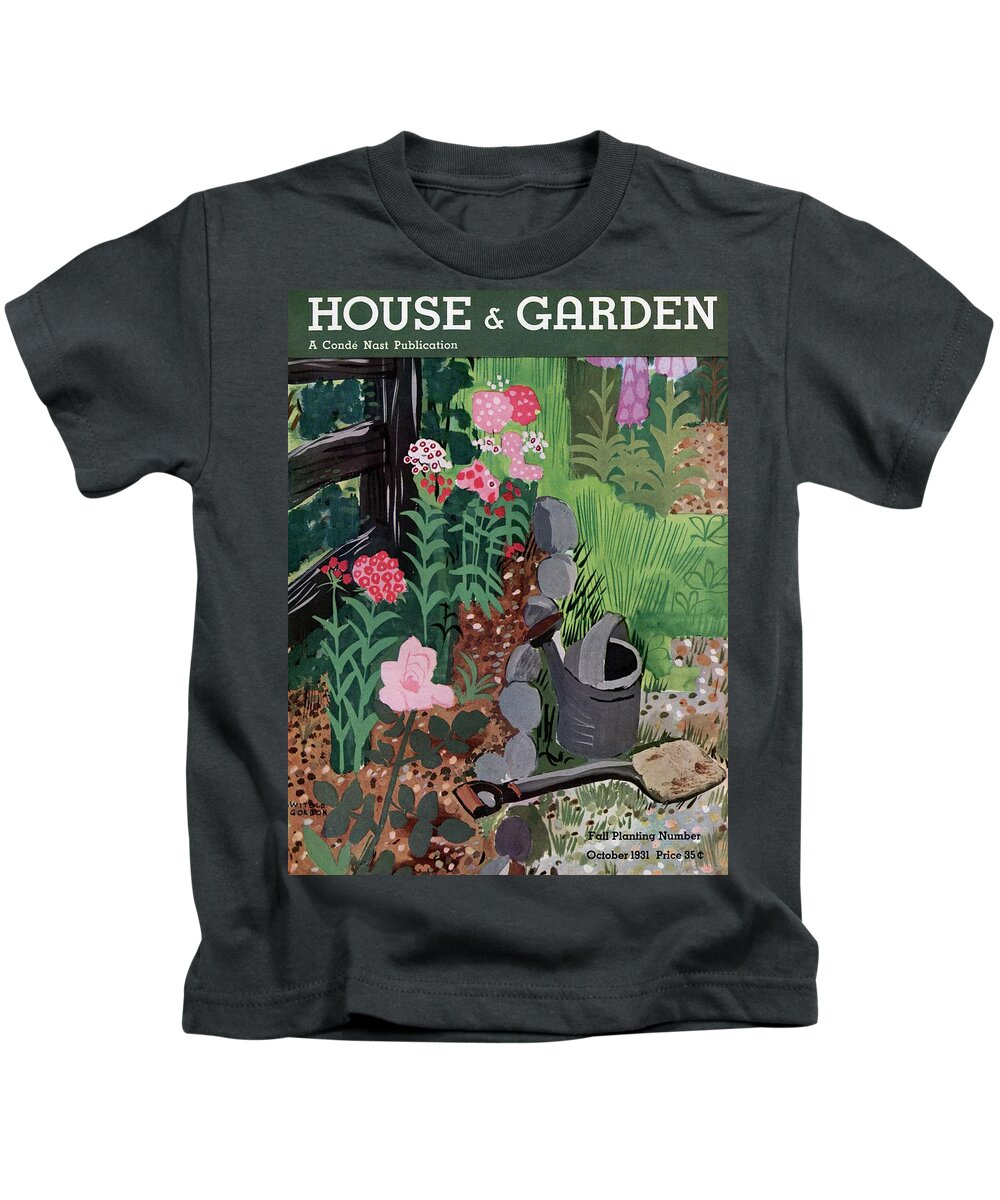 House And Garden Kids T-Shirt featuring the photograph A Watering Can And A Shovel By A Flower Bed by Witold Gordon