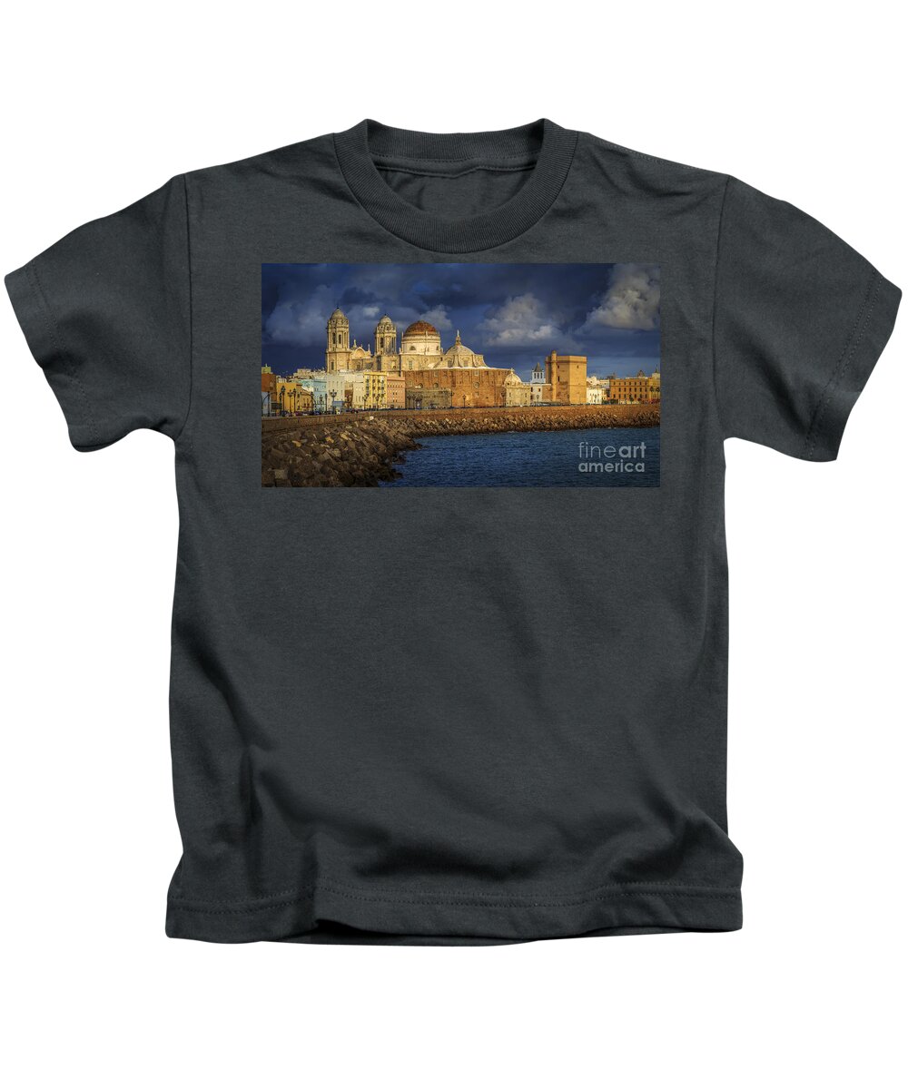 Andalucia Kids T-Shirt featuring the photograph Stormy Skies Over the Cathedral Cadiz spain by Pablo Avanzini