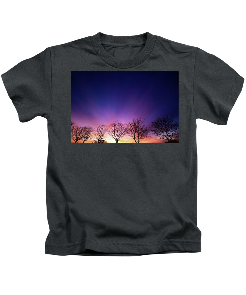 Sunset Kids T-Shirt featuring the photograph Fiery winter sunset with line of bare trees by Simon Bratt
