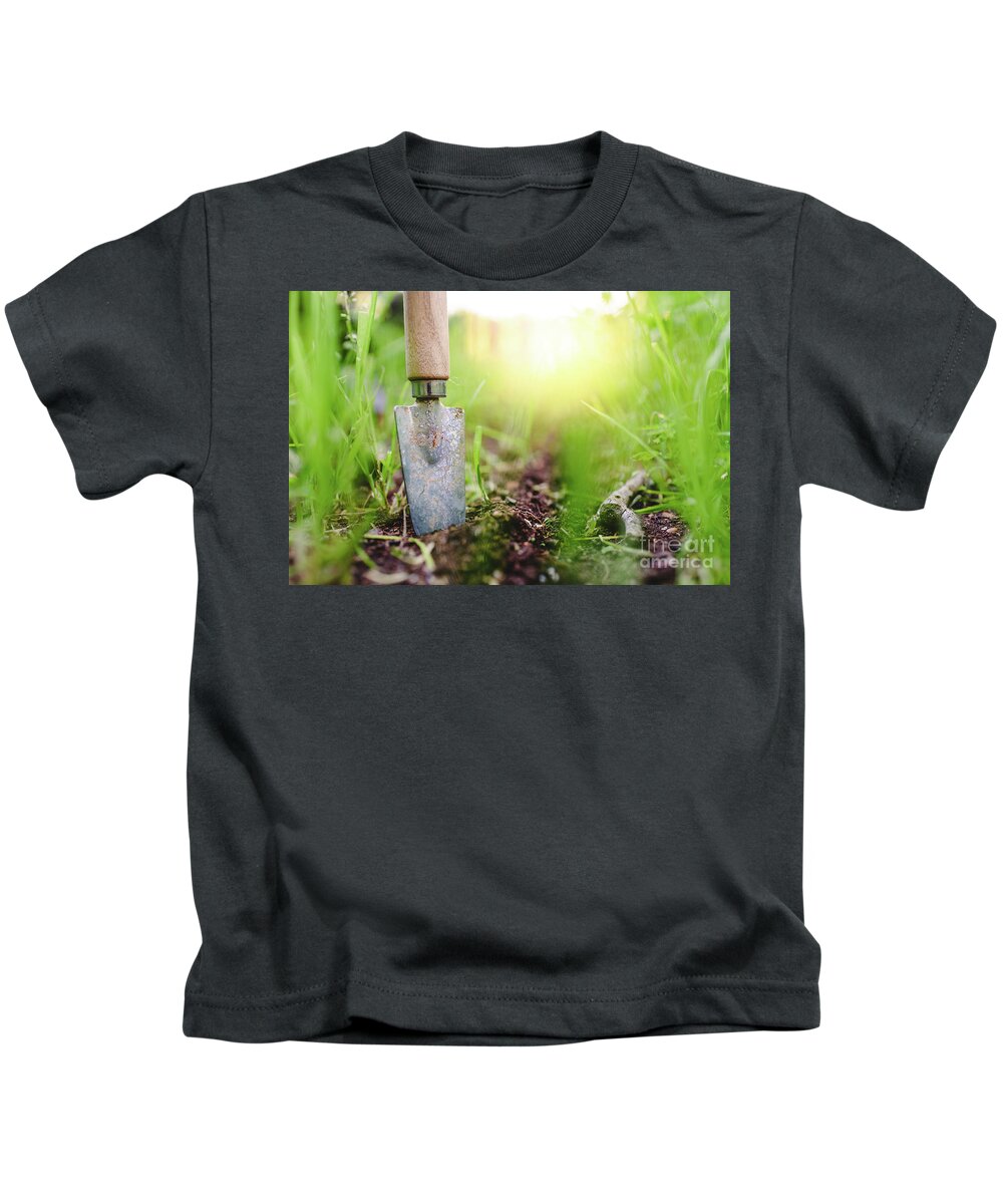Agricultural Kids T-Shirt featuring the photograph Gardening shovel in an orchard during the gardener's rest by Joaquin Corbalan