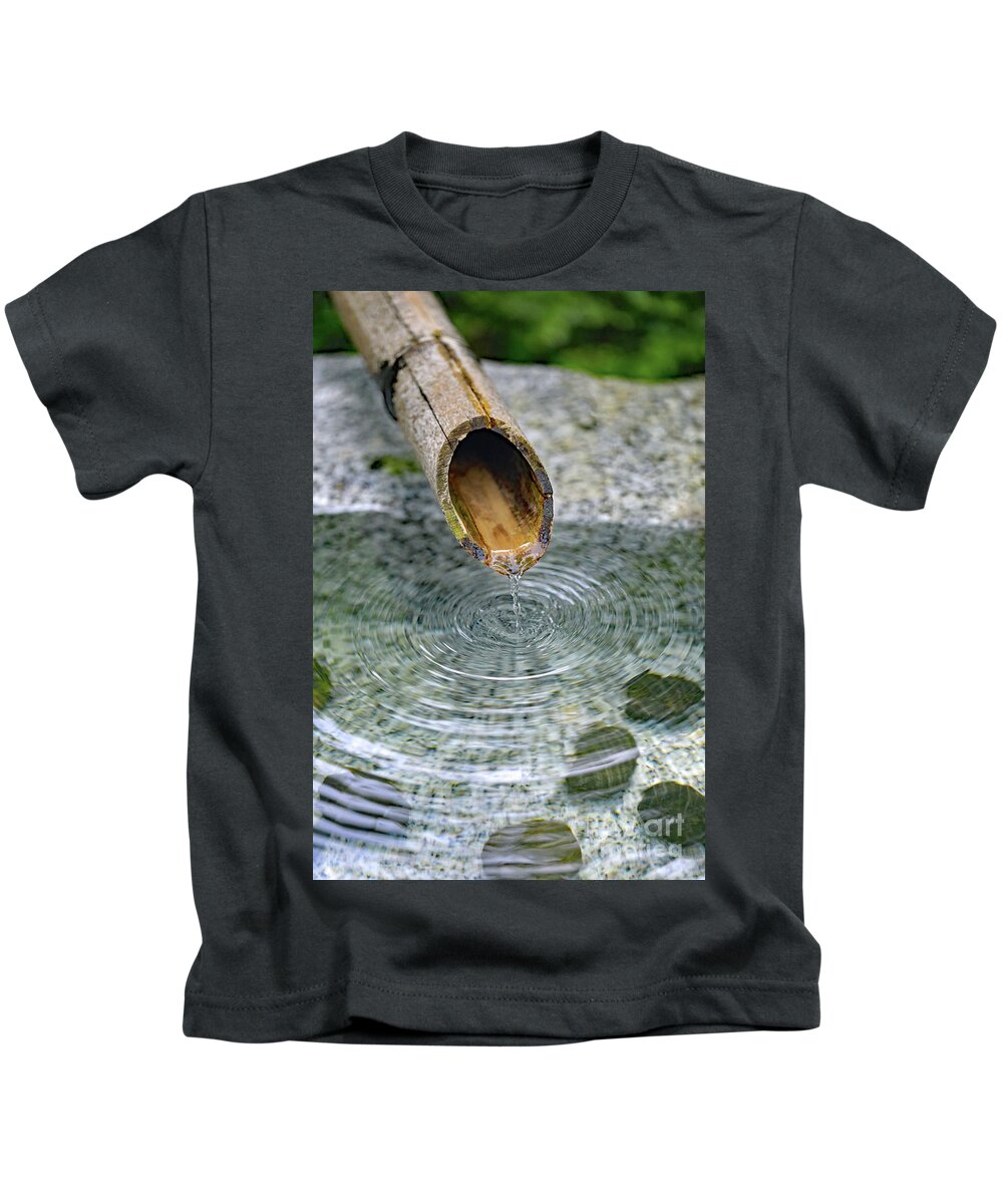 Water Fountain; Fountain; Japanese Fountain; Japanese Garden; Zen; Water; Drip; Droplets; Bamboo; Pool; Stone; Pebbles; Green; Kids T-Shirt featuring the photograph In a Japanese Garden by Tina Uihlein