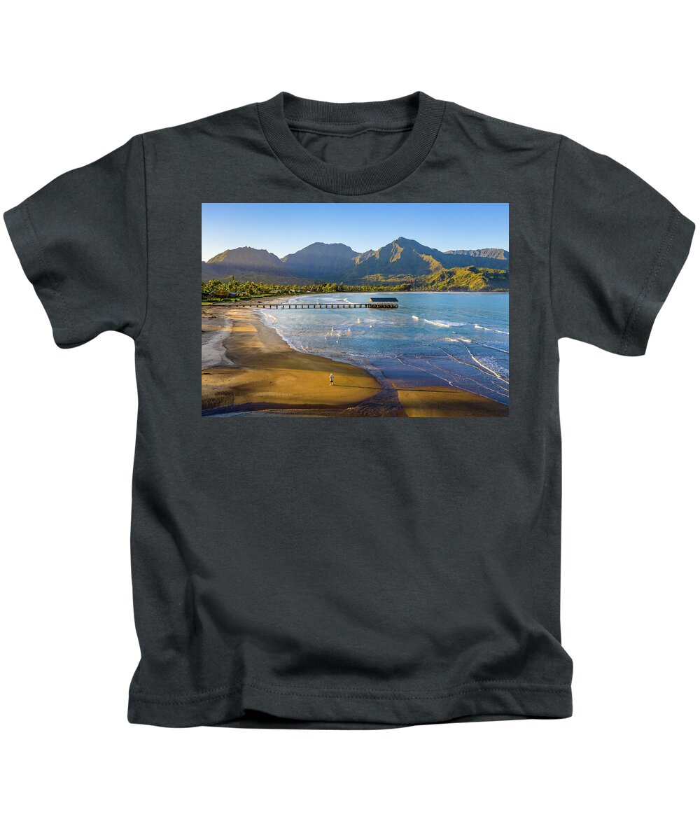 Aerial Kids T-Shirt featuring the photograph Lone man on the sand of Hanalei beach on the nor by Steven Heap