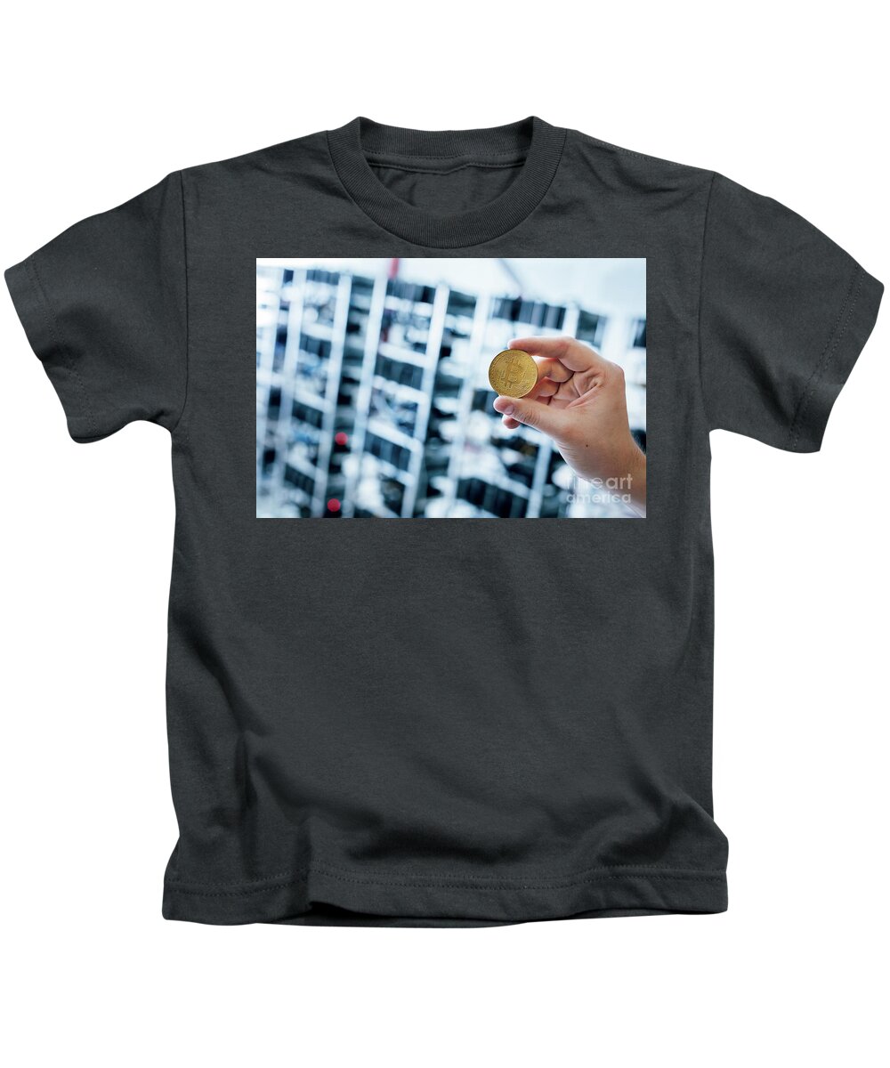 Bitcoin Kids T-Shirt featuring the photograph Man's hand showing bitcoin coin by Michal Bednarek