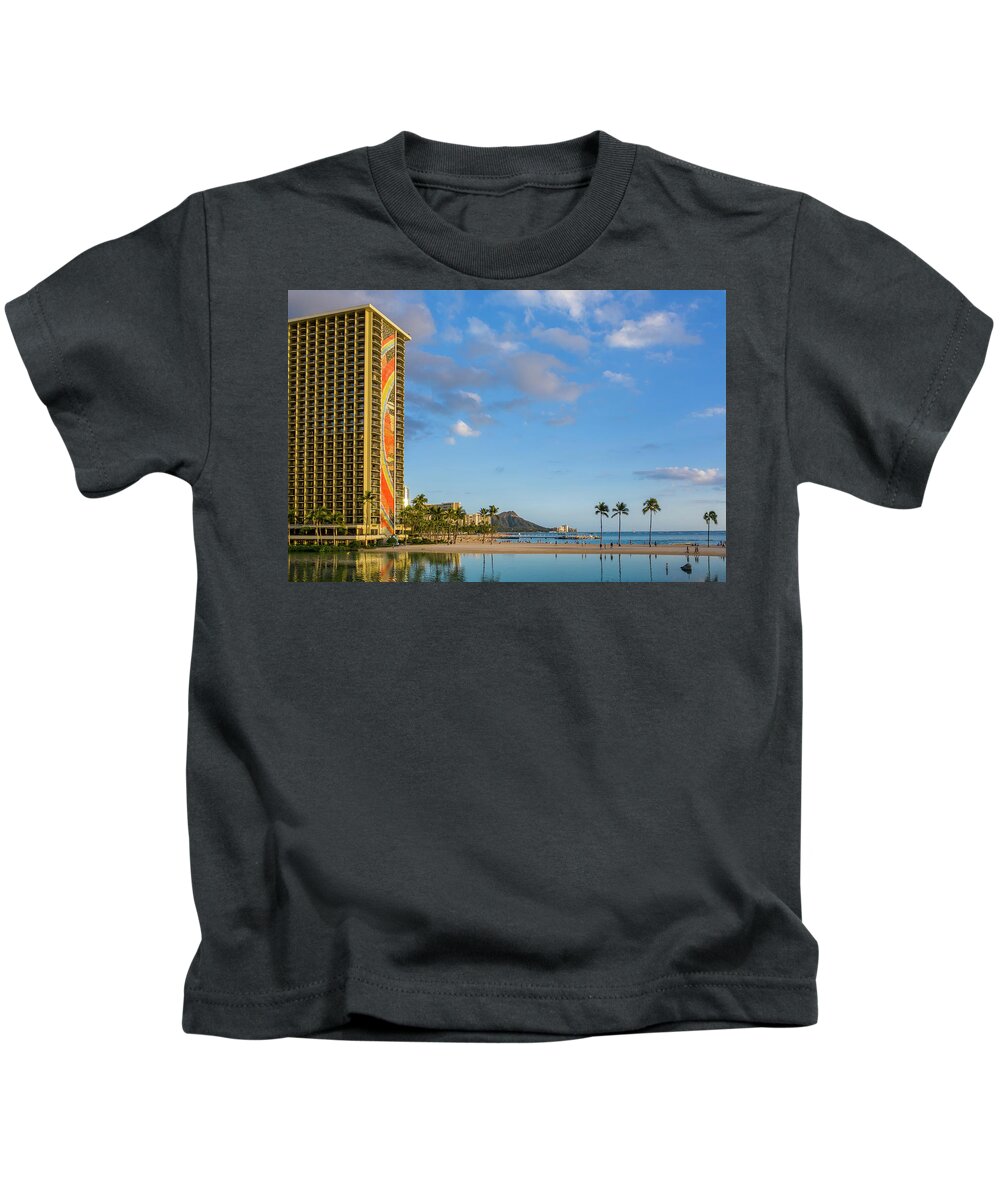 Waikiki Kids T-Shirt featuring the photograph Rainbow tower frames the shore in Waikiki Hawaii by Steven Heap