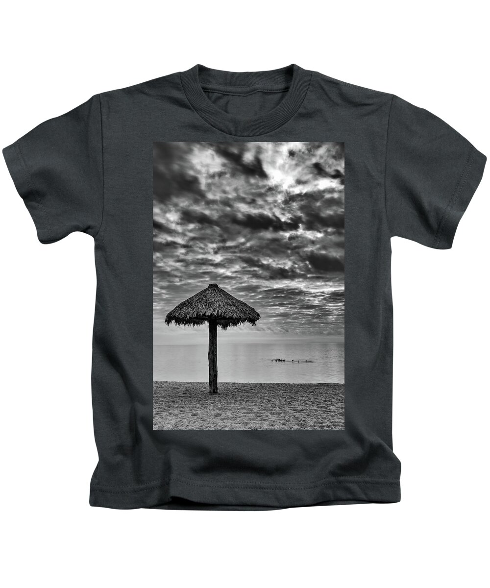 Beach Kids T-Shirt featuring the photograph Straw Beach Umbrella on a cloudy day on Rockport Beach, TX by David Ilzhoefer