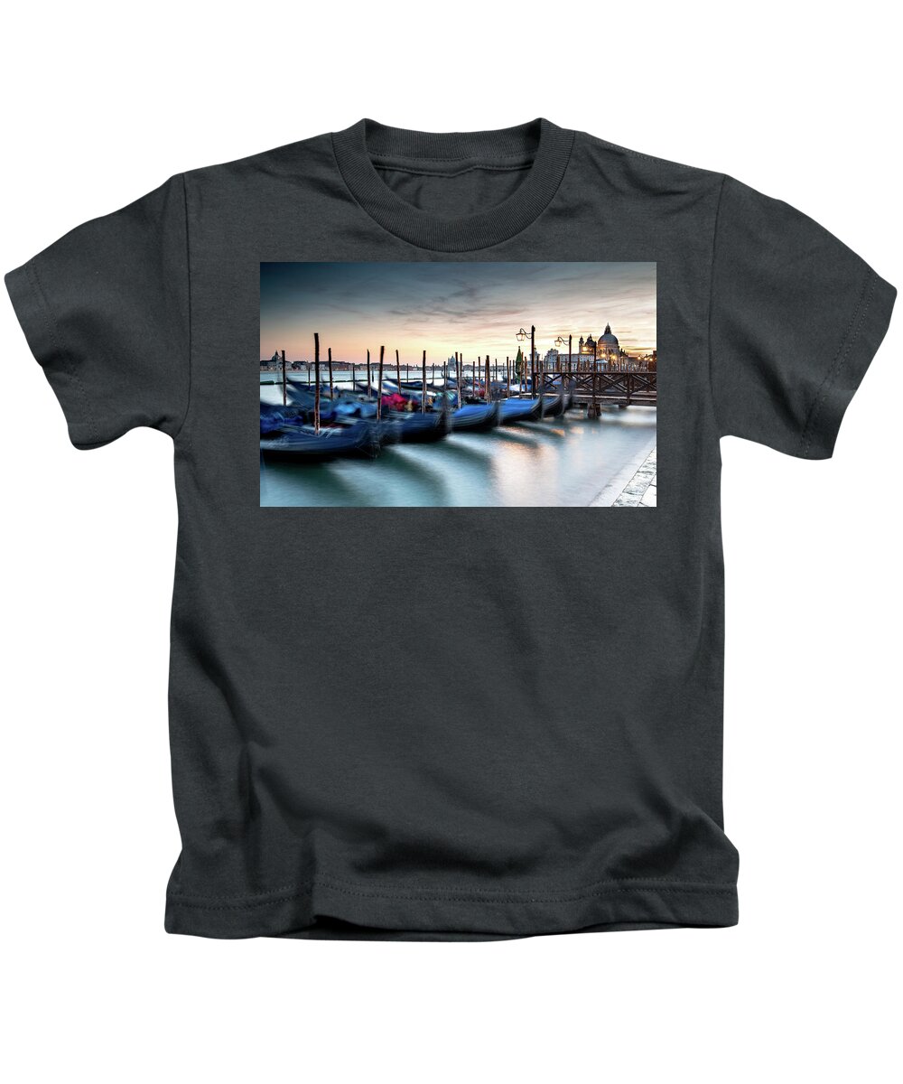Gondola Kids T-Shirt featuring the photograph Venice Gondolas moored at the San Marco square. by Michalakis Ppalis
