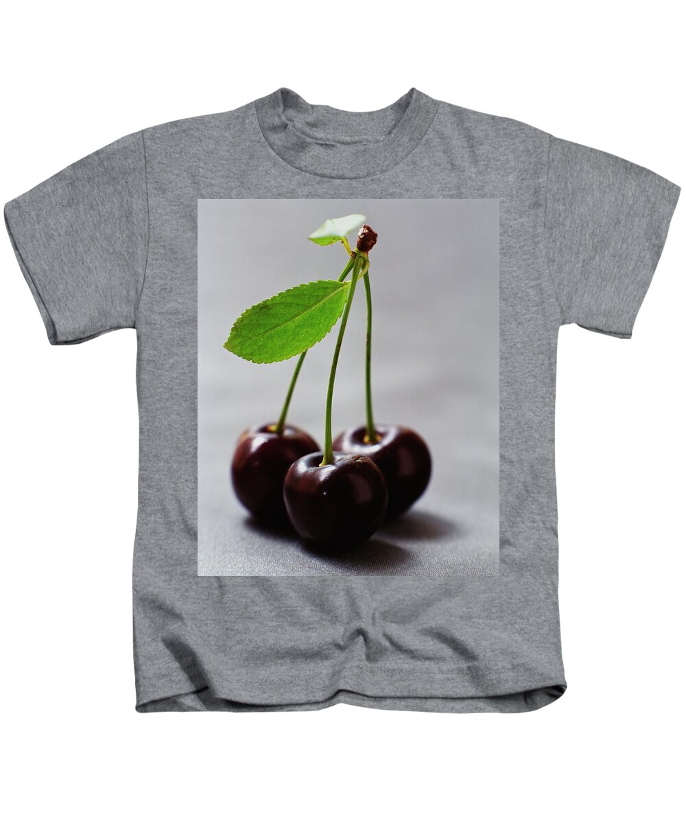 Fruits Kids T-Shirt featuring the photograph Three Cherries On A Stem by Romulo Yanes