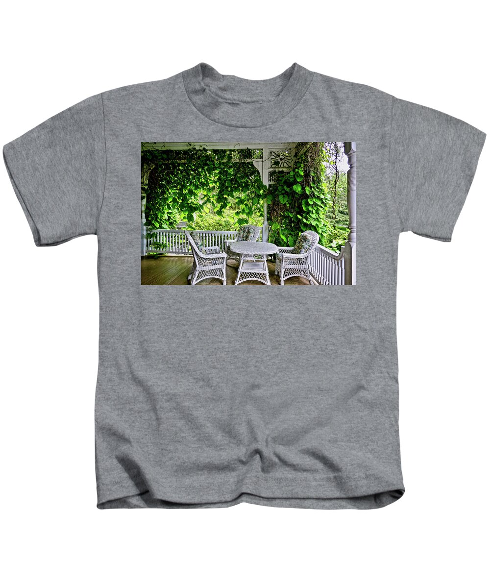 Beautiful Color Photograph Of Porch With Wicker Table And Chairs Kids T-Shirt featuring the photograph A Beautiful Porch View by Joan Reese