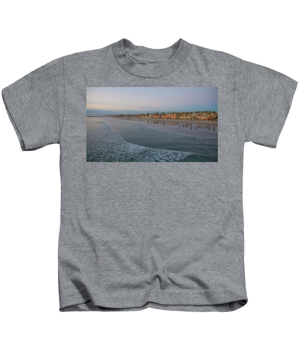 View Of Coast From Oceanside Pier Kids T-Shirt featuring the photograph Oceanside California Sunset City Light Reflection on Pacific by Catherine Walters