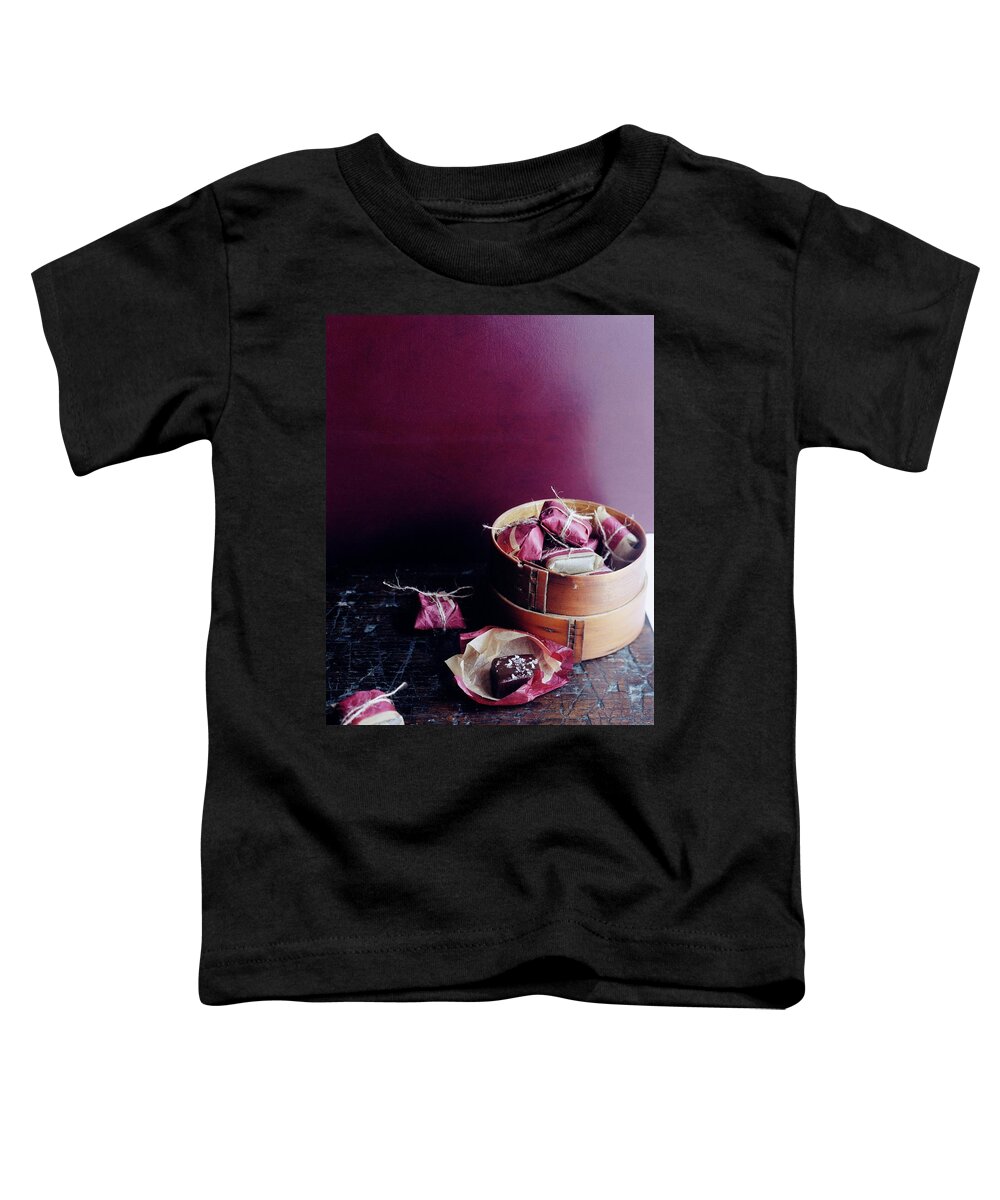 Cooking Toddler T-Shirt featuring the photograph A Bamboo Steamer With Paper Packages by Romulo Yanes
